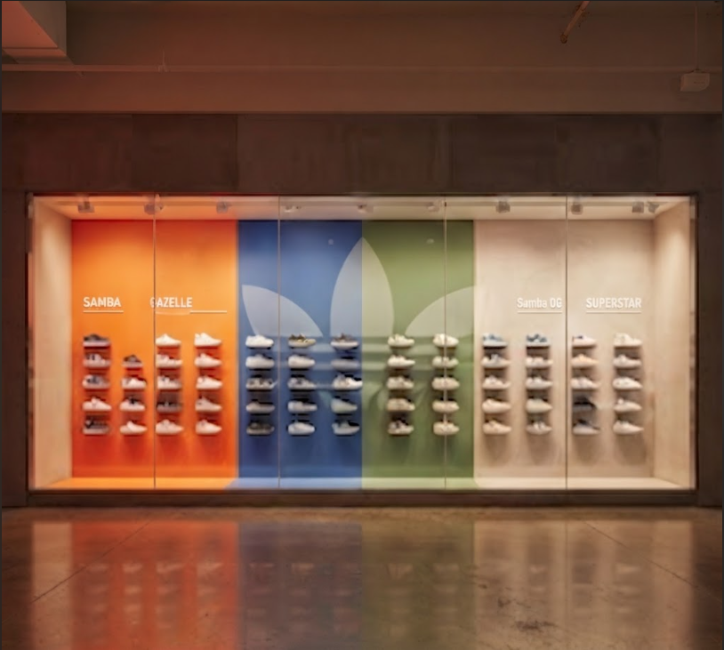 Color-blocked retail wall installation organizing footwear collections across vibrant, partitioned color panels.