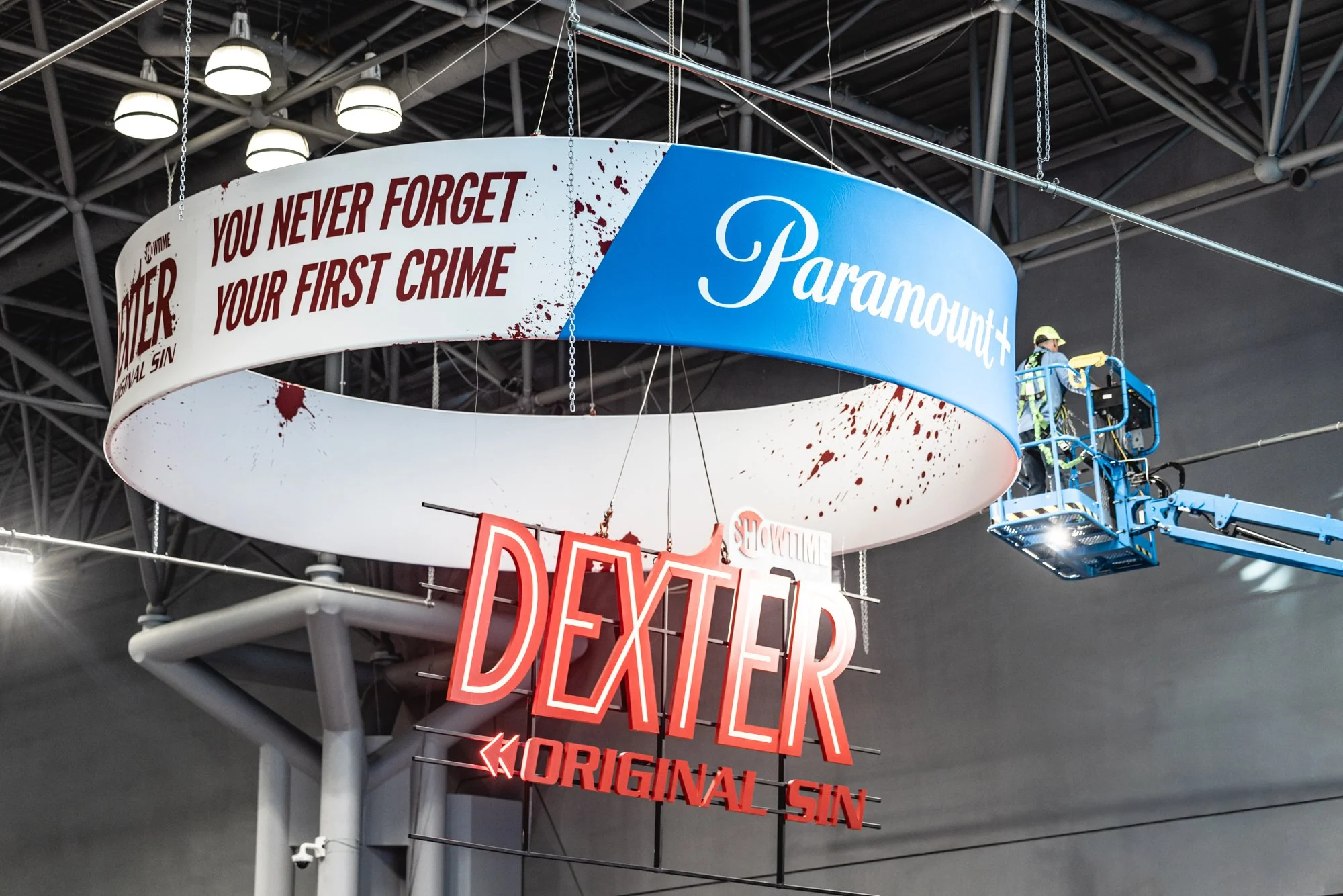 Paramount Showtime Dexter display featuring the “You Never Forget Your First Crime” slogan and a worker on a lift