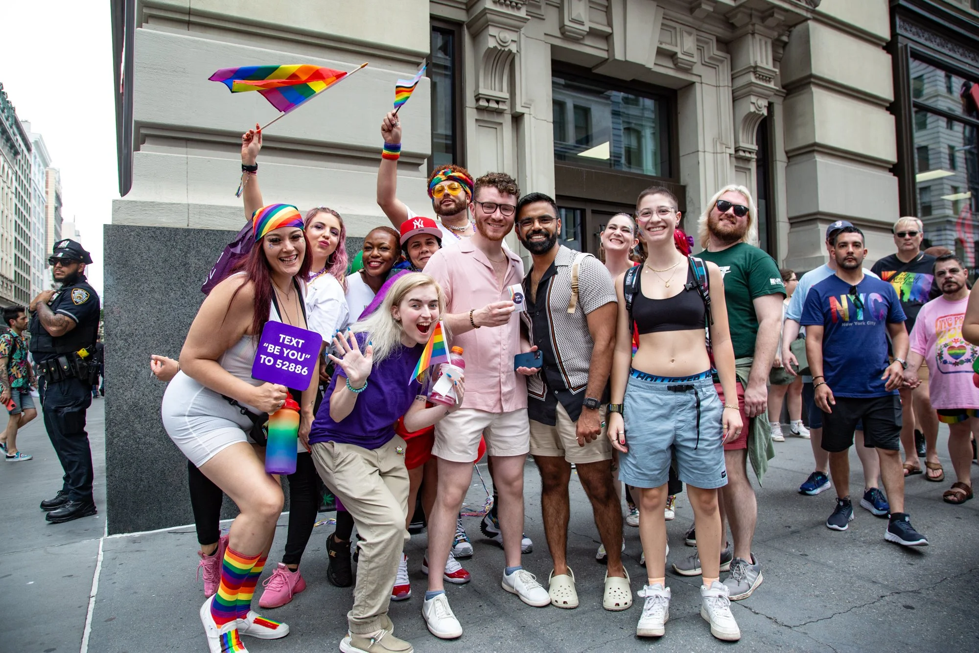 Group of people celebrating Pride in New York City with rainbow flags and LGBTQ+ attire