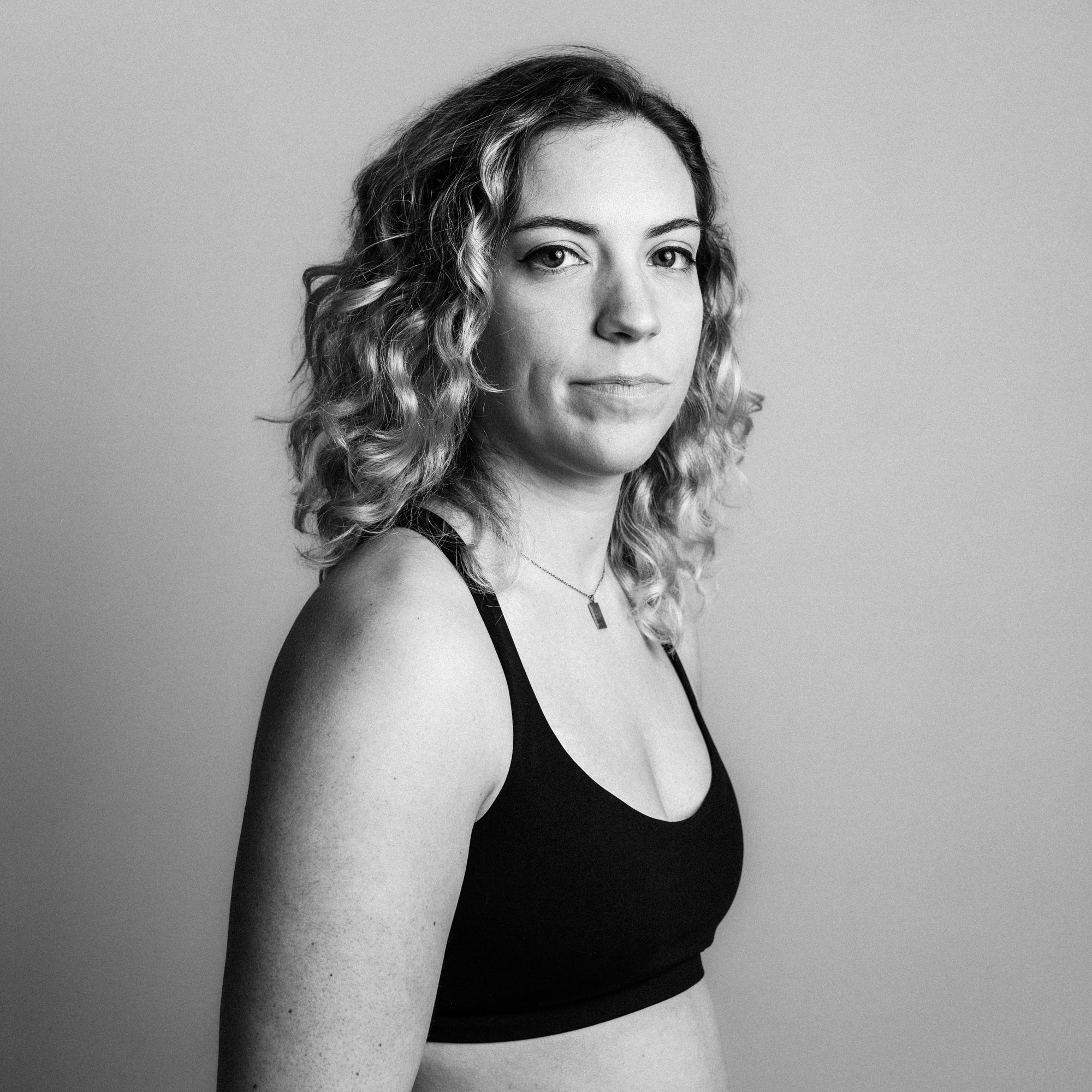 Woman in workout top staring directly into camera. 