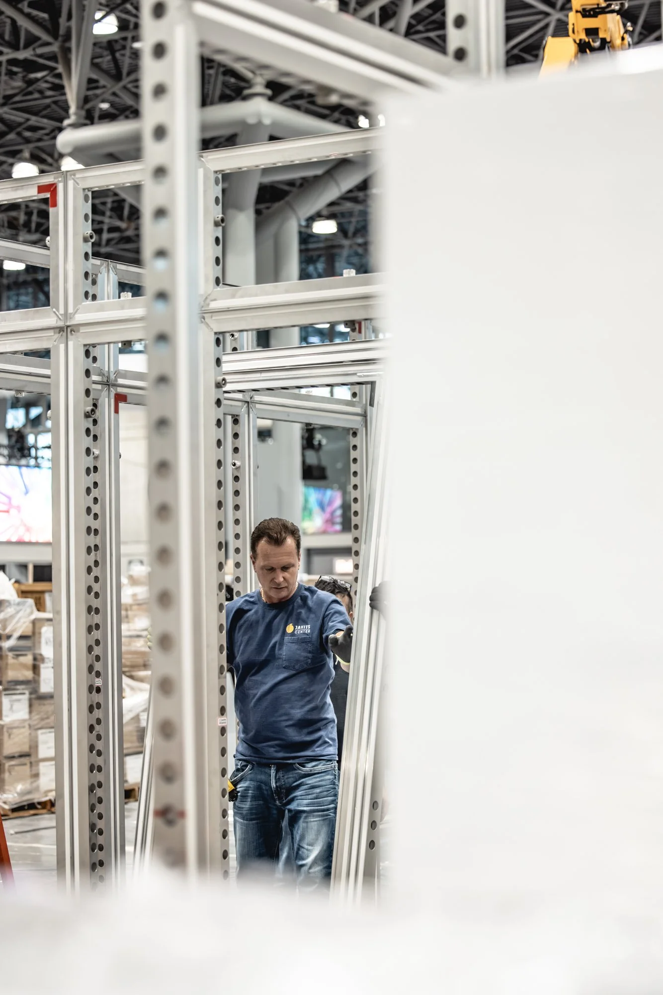Worker assembling a metal display structure at the Javits Center