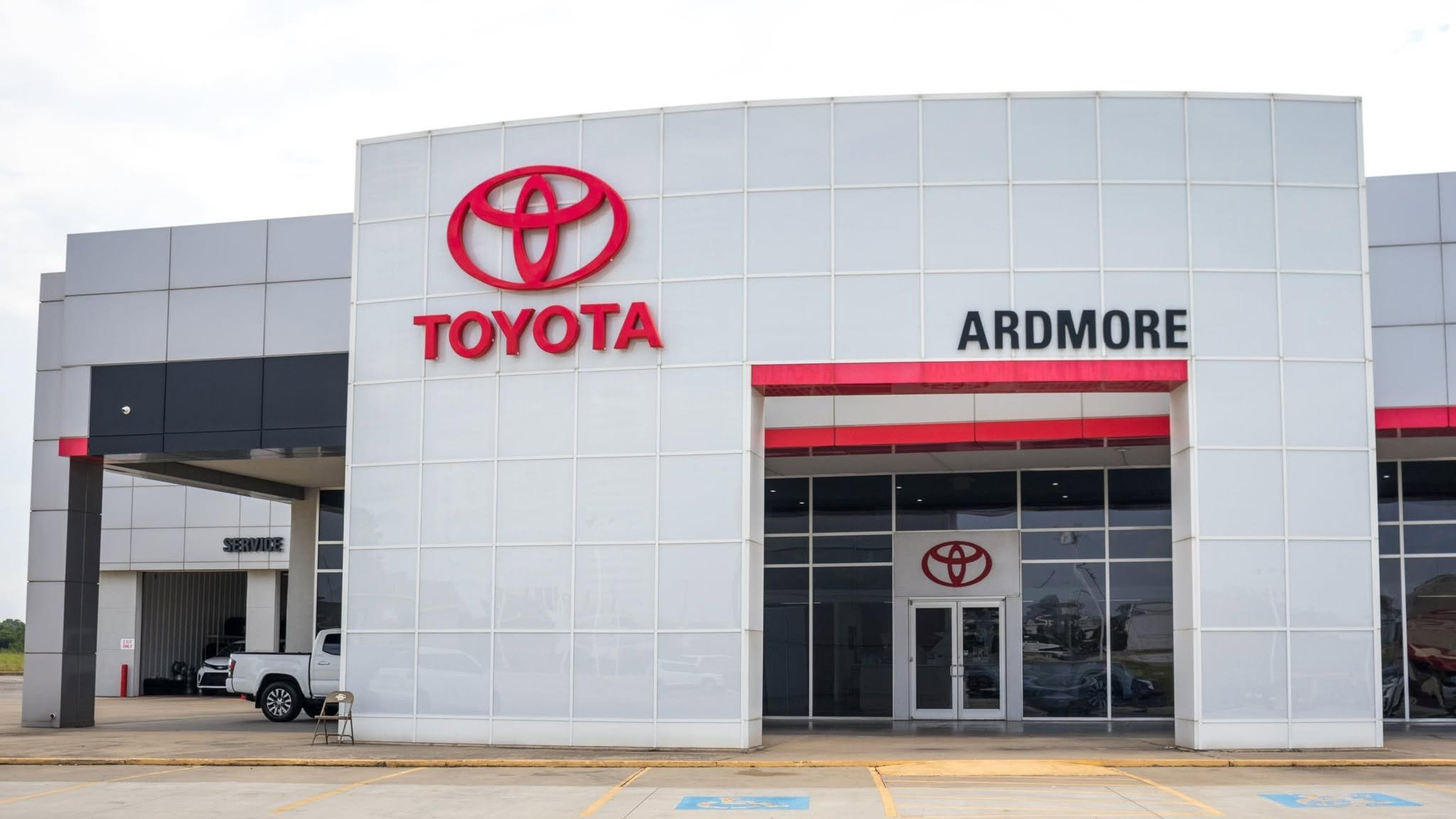 Coldview of a Toyota car dealership building with Toyota logo and sign reading 'ARDMORE' on the front.