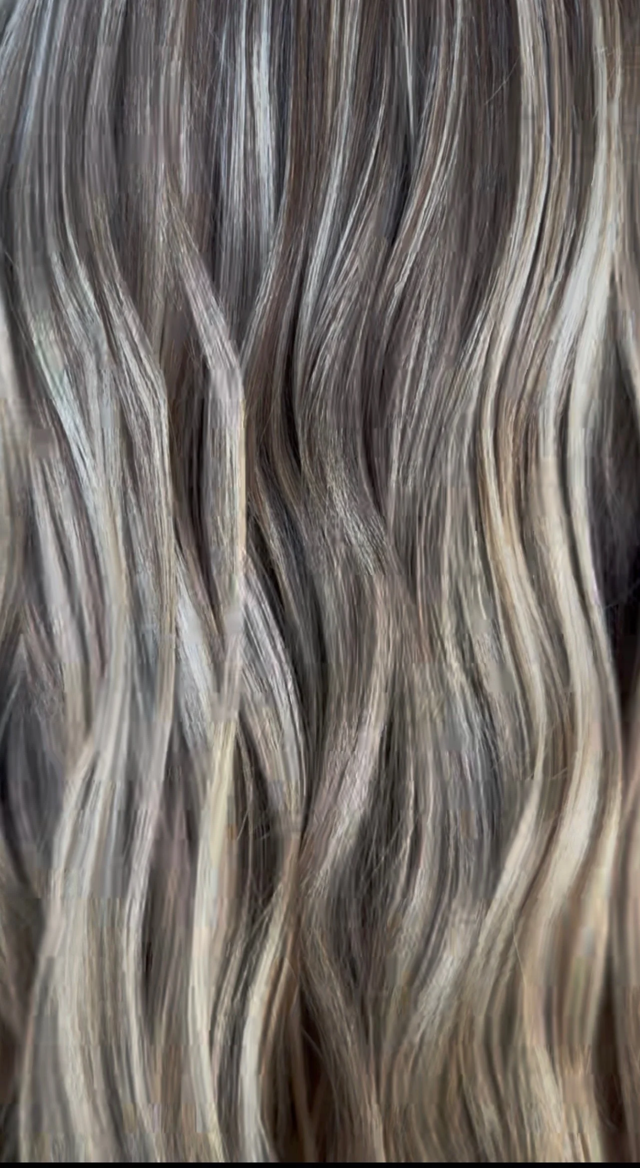 Close-up of layered, wavy, grayish-brown hair.