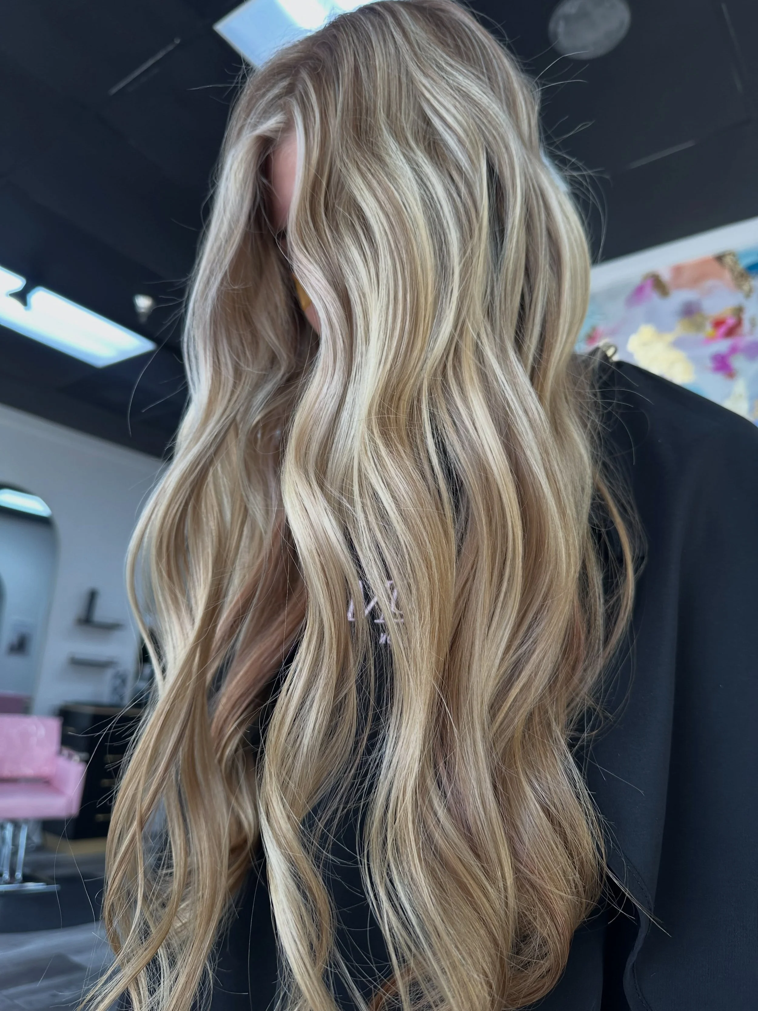 Long, blonde, wavy hair in a salon setting.