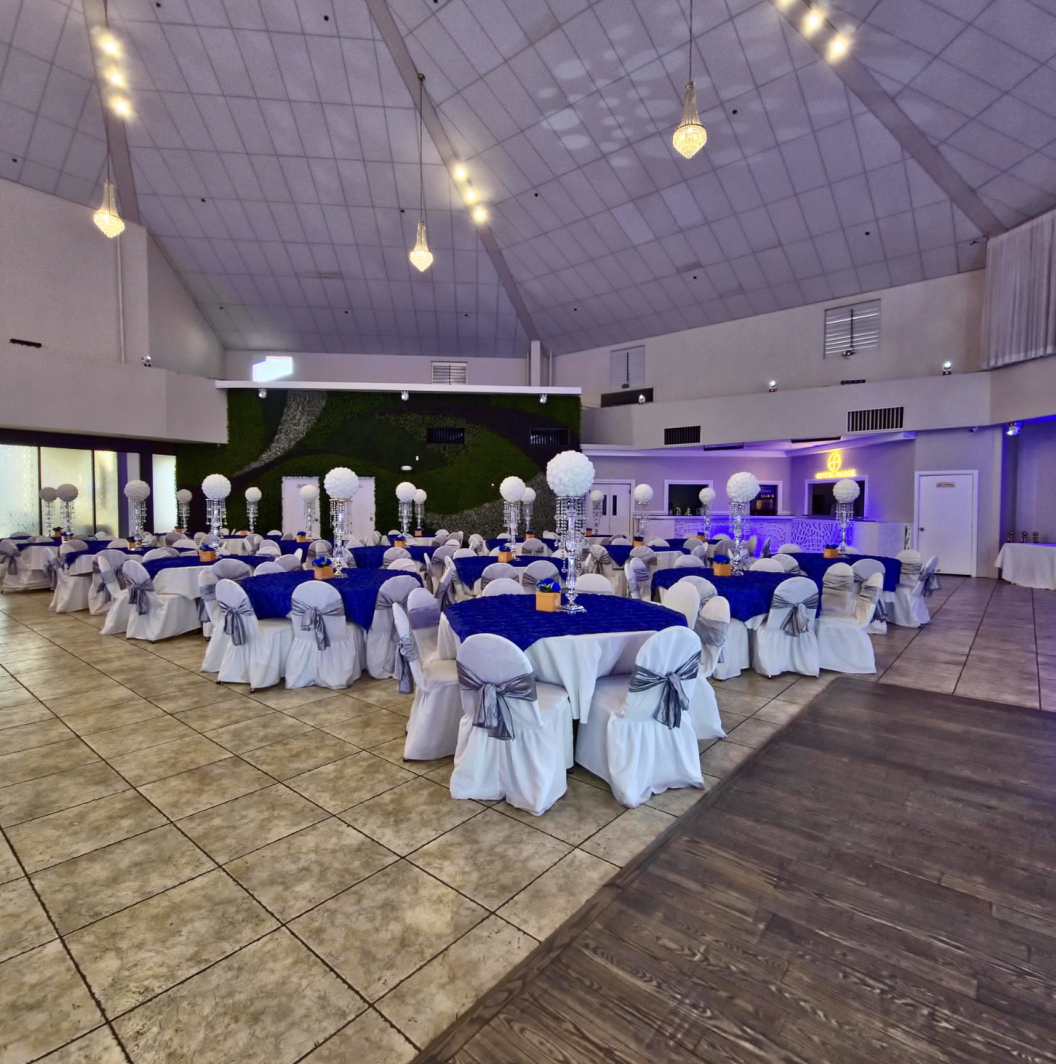 Crystal Palace Ballroom reception layout featuring decorated tables, white chair covers, and blue accent lighting.