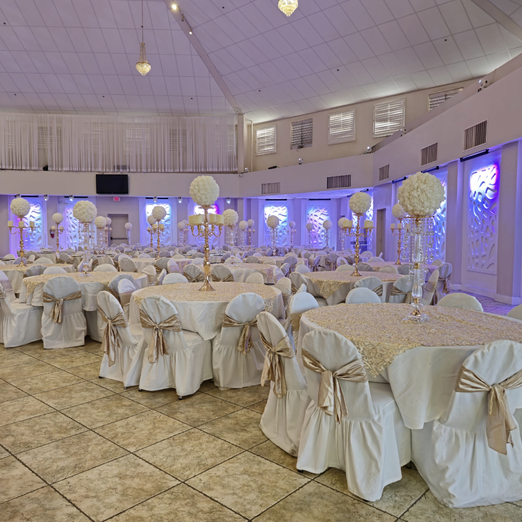 Crystal Palace Ballroom decorated with white-covered tables and chairs for a formal celebration.