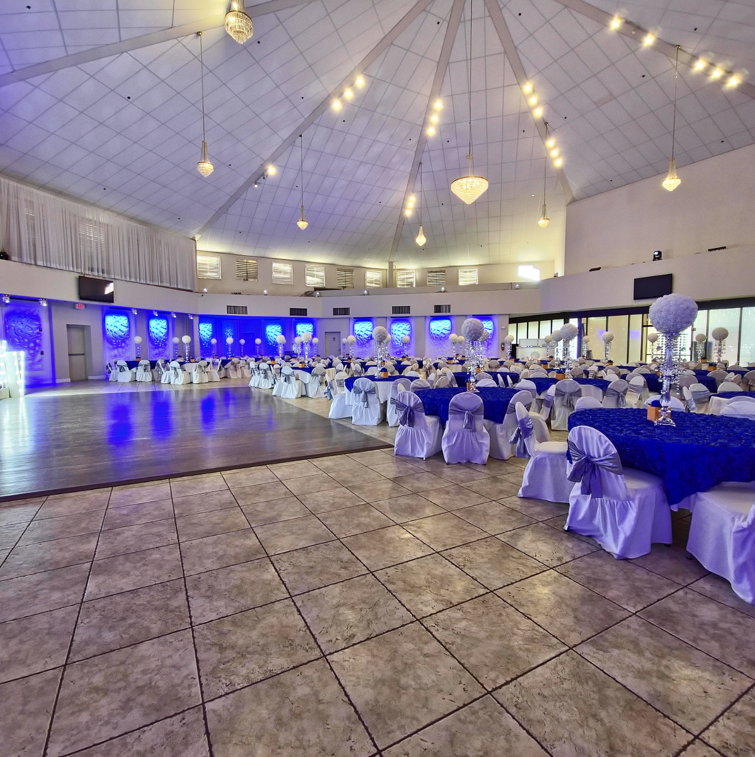 Wide view of Crystal Palace Ballroom featuring a large dance floor, banquet seating, and blue accent lighting.
