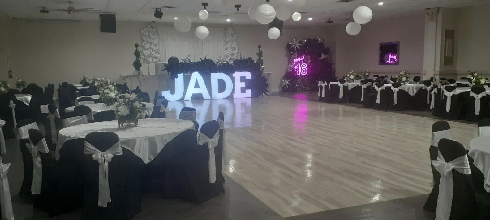 Personalized celebration display featuring illuminated letters and purple accent lighting inside the venue.