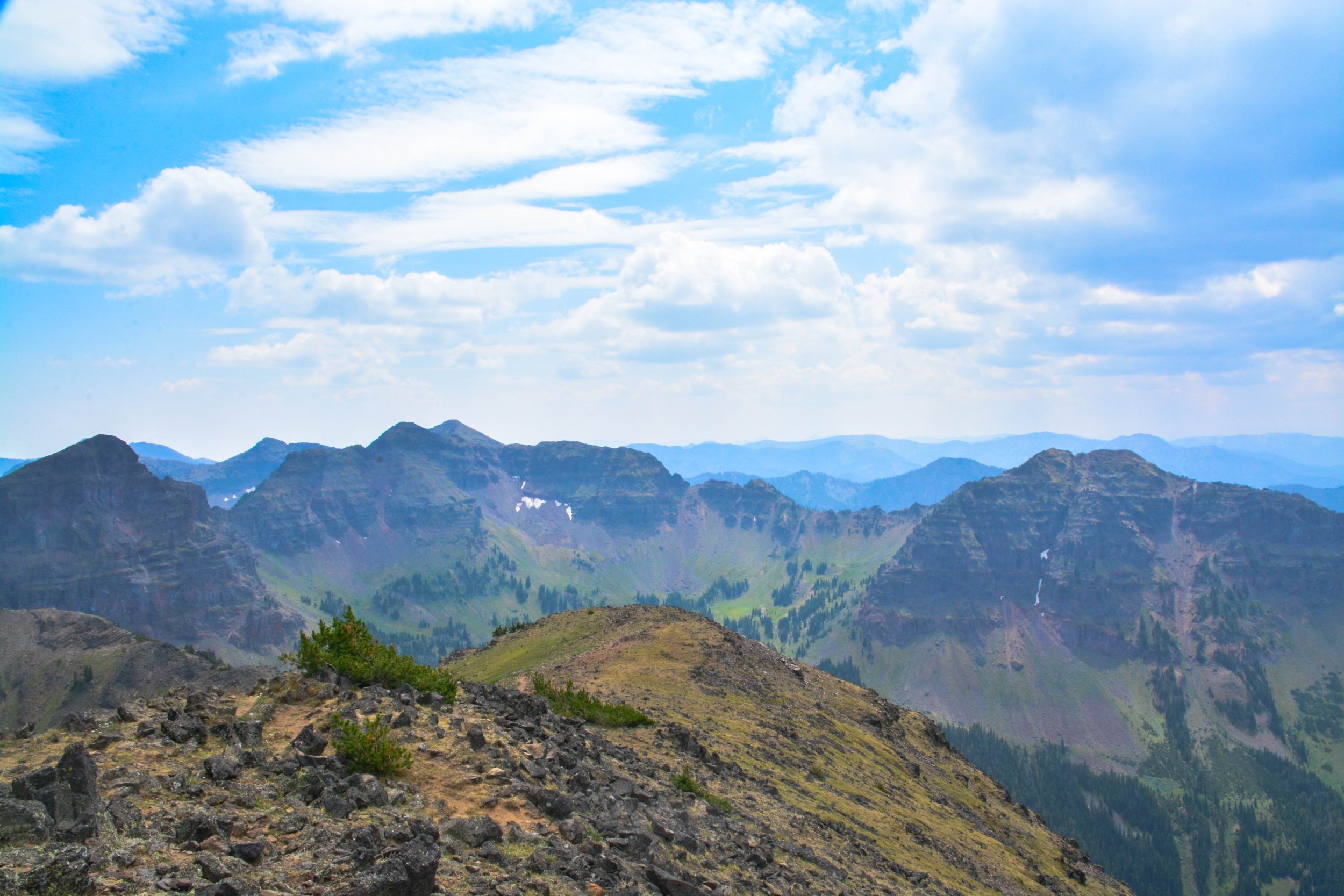 Tall mountain peaks under a blue sky with scattered clouds.