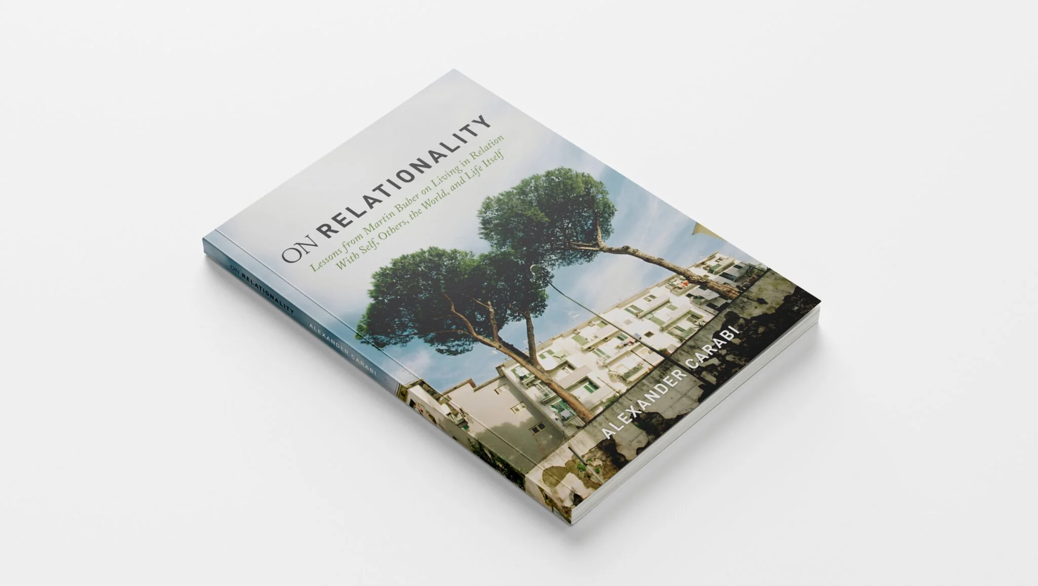 A book titled 'On Relationality' by Alexander Carabi with a cover image of a large tree growing among apartment buildings on a city street.