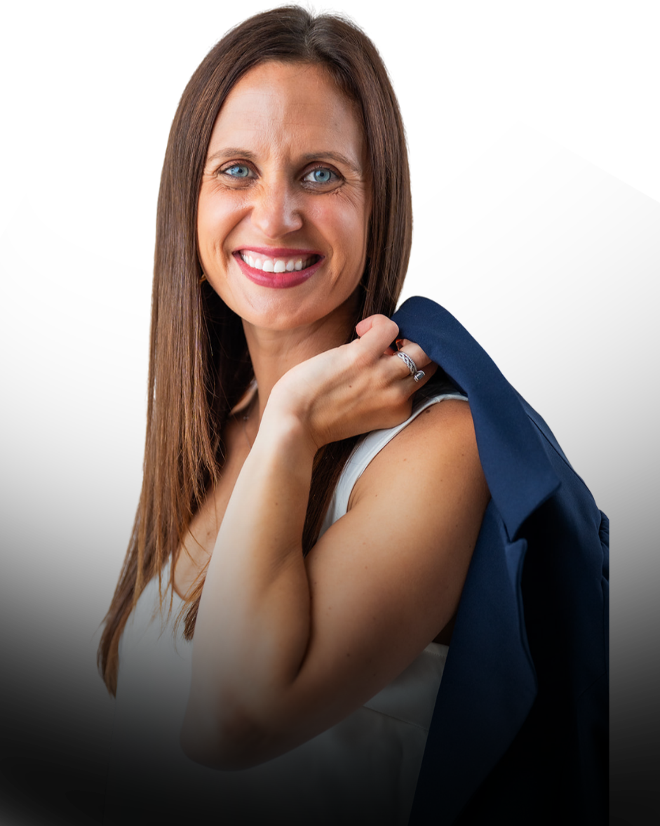 Lisa Tarkington - A woman smiling with blue eyes and long brown hair, holding a dark blue blazer over her shoulder.