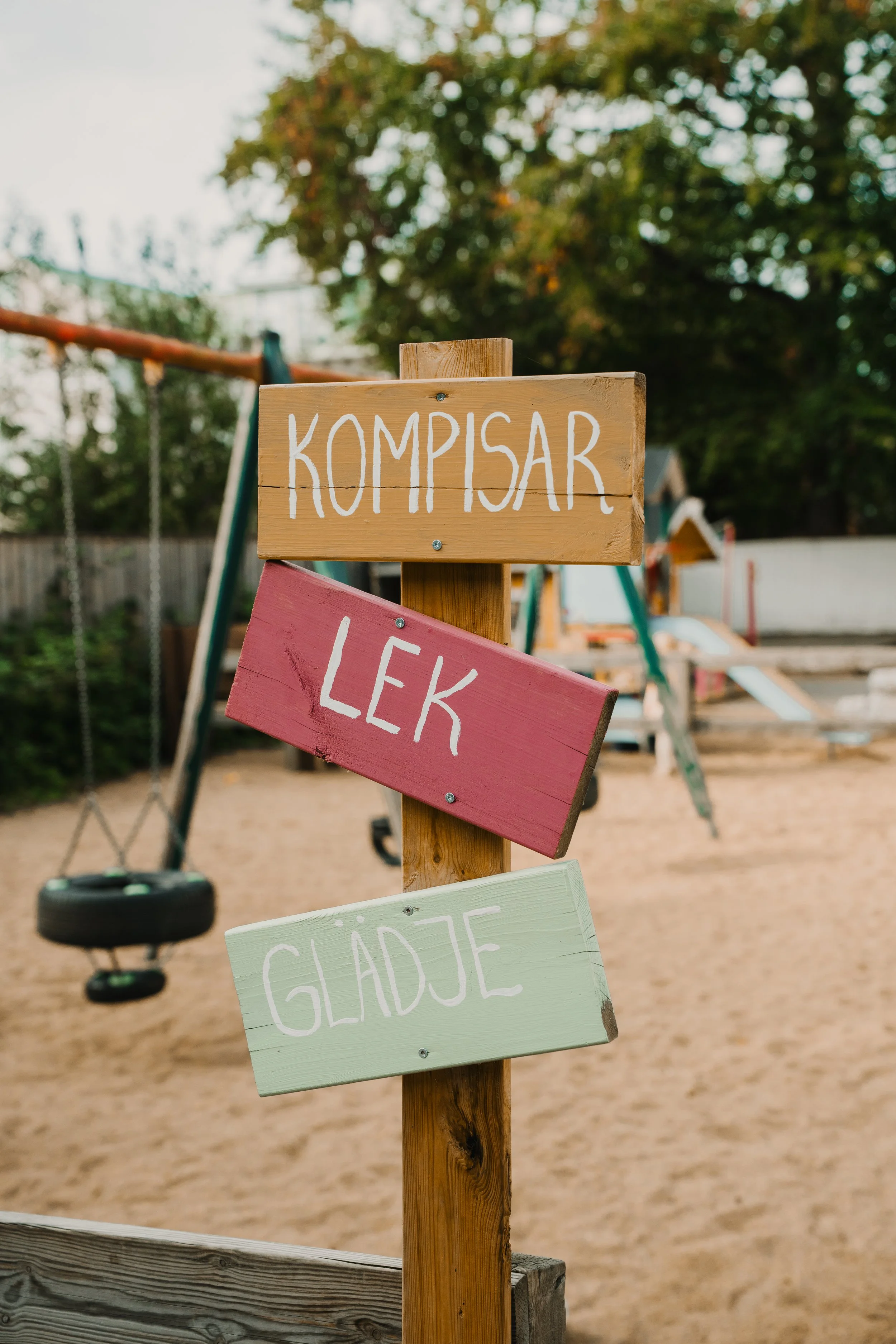 Väggen med skyltar med text i en lekplats.
