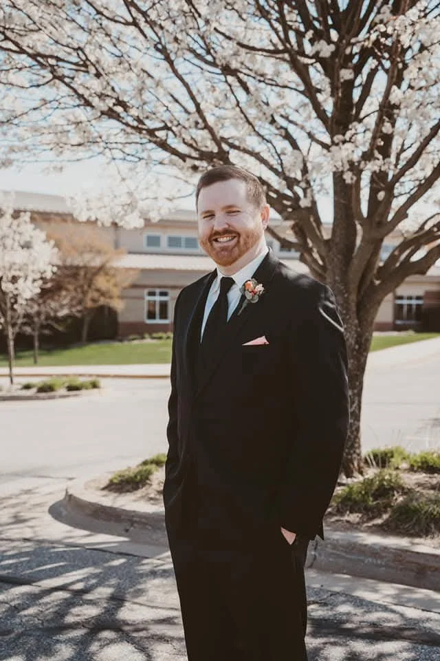 brad in a suit smiling outside