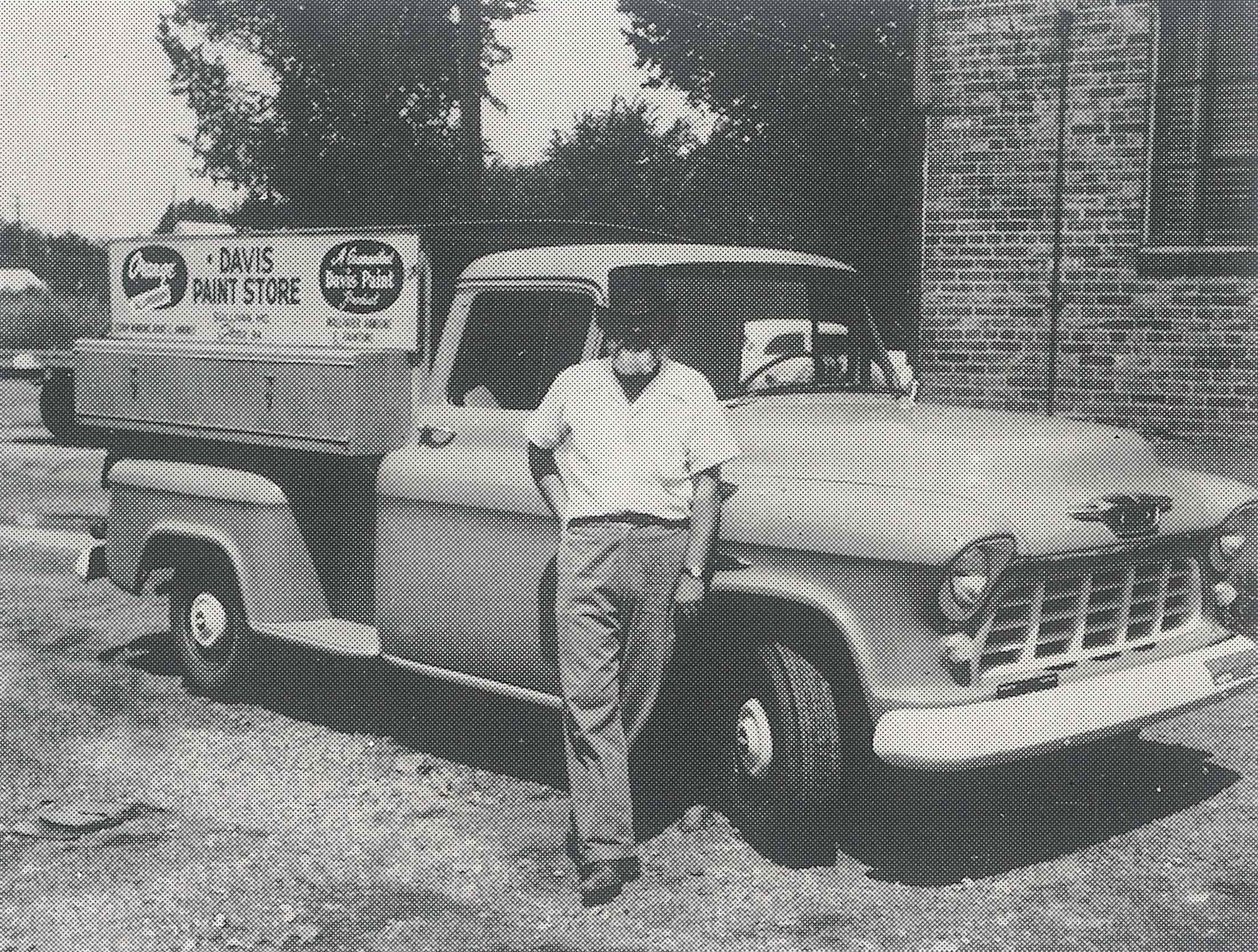 a black and white photograph of Barry Davis standing in front of a chevy pickup truck
