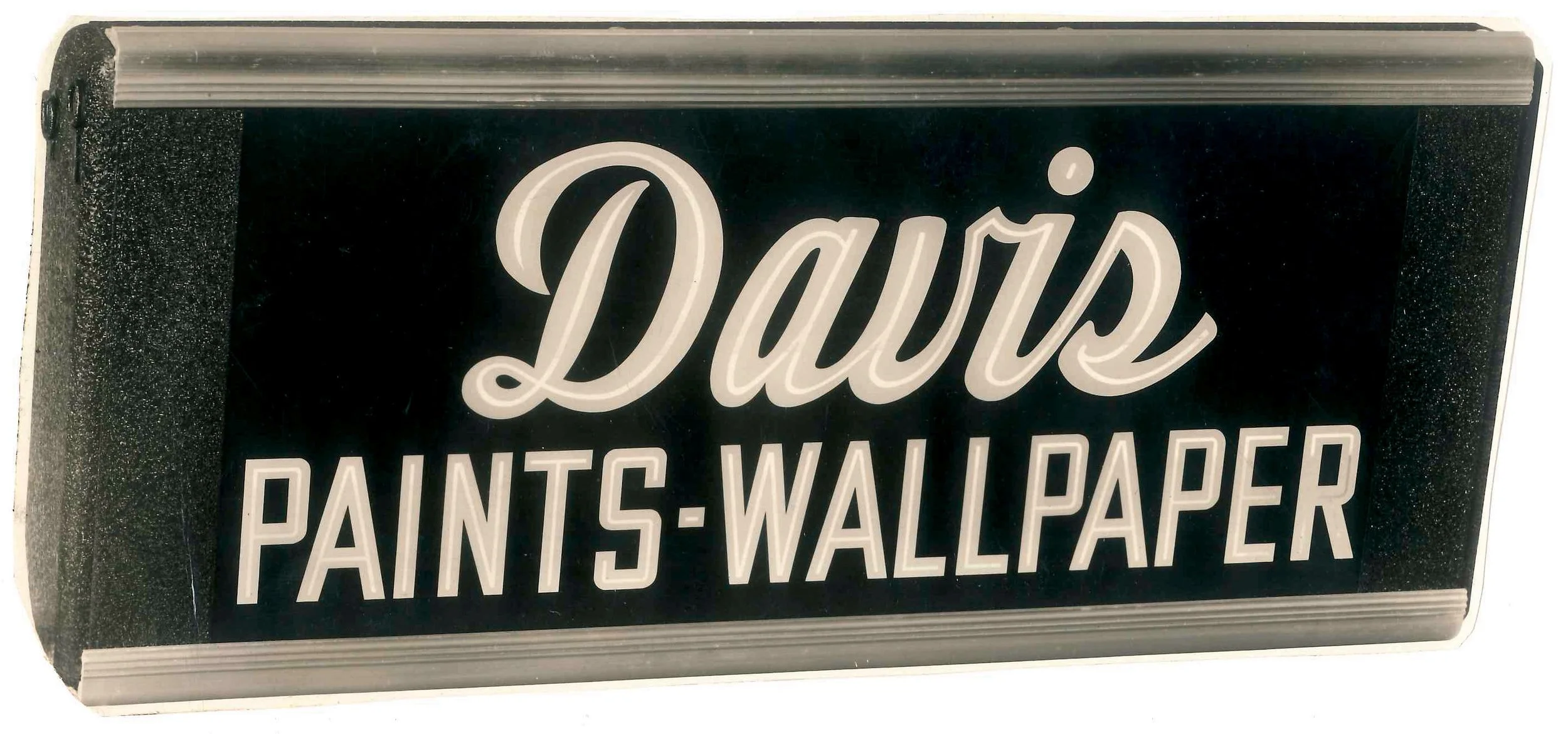 Signboard with the words 'Davis' in large cursive font and 'PAINTS WALLPAPER' in capital letters underneath.