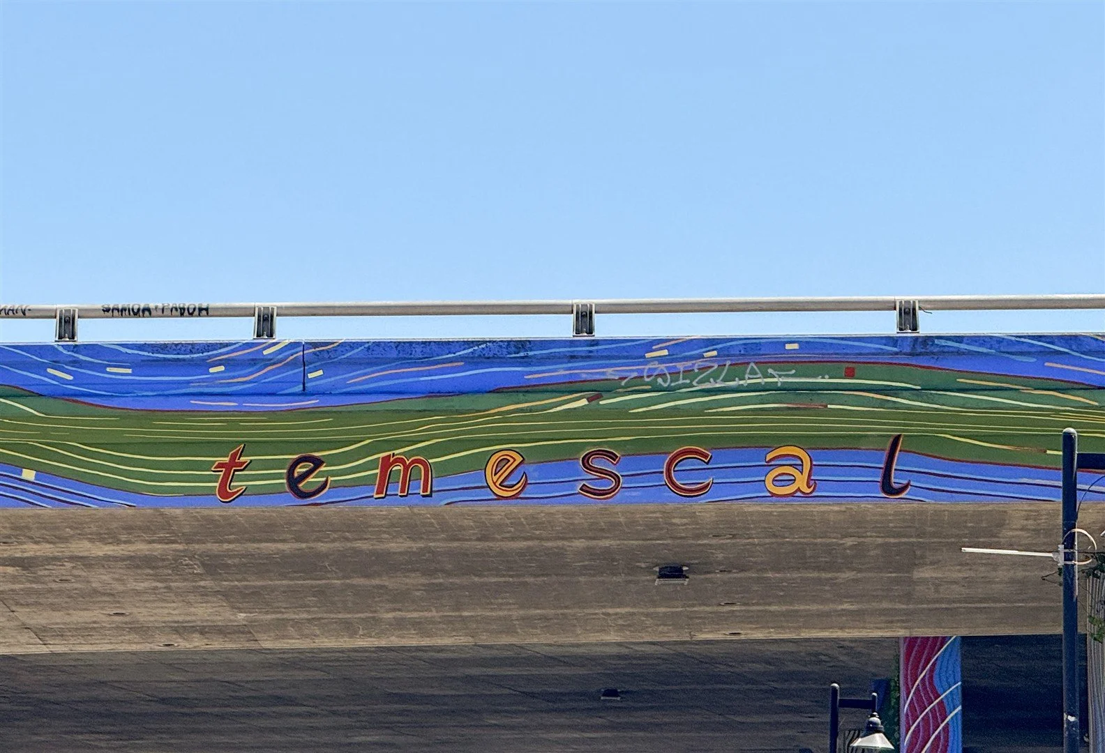 Colorful sign for Temescal underneath a blue sky.