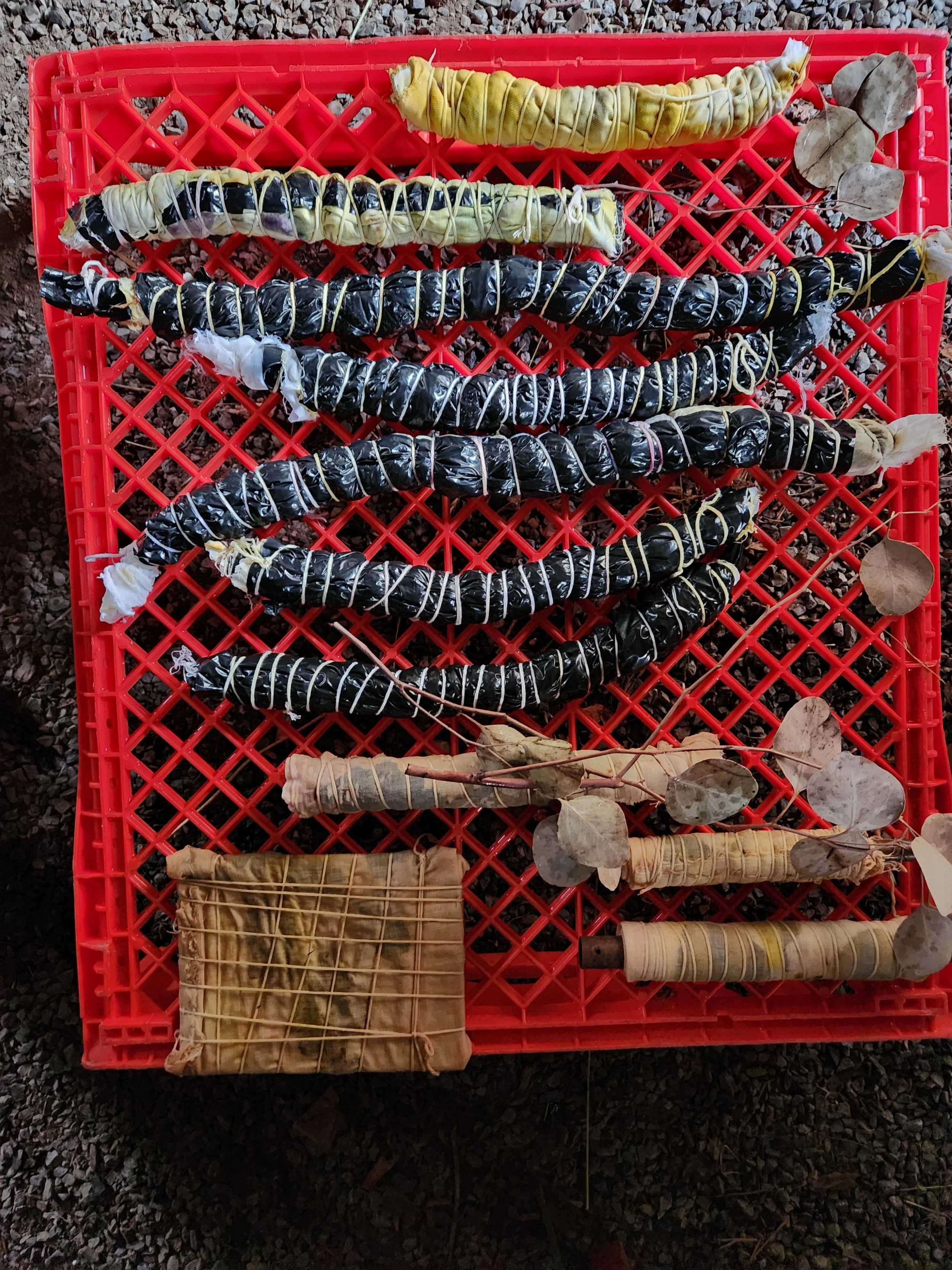 Eco-bundle dyeing exploration with natural leaf prints and earthy botanical textures on raw fabric