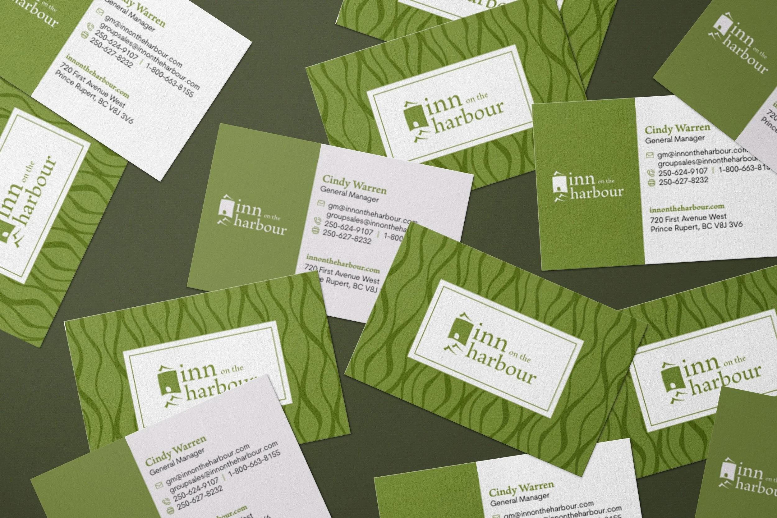 A collection of business cards for Inn on the Harbour, featuring green and white colors, with contact information for Cindy Warren, the general manager.