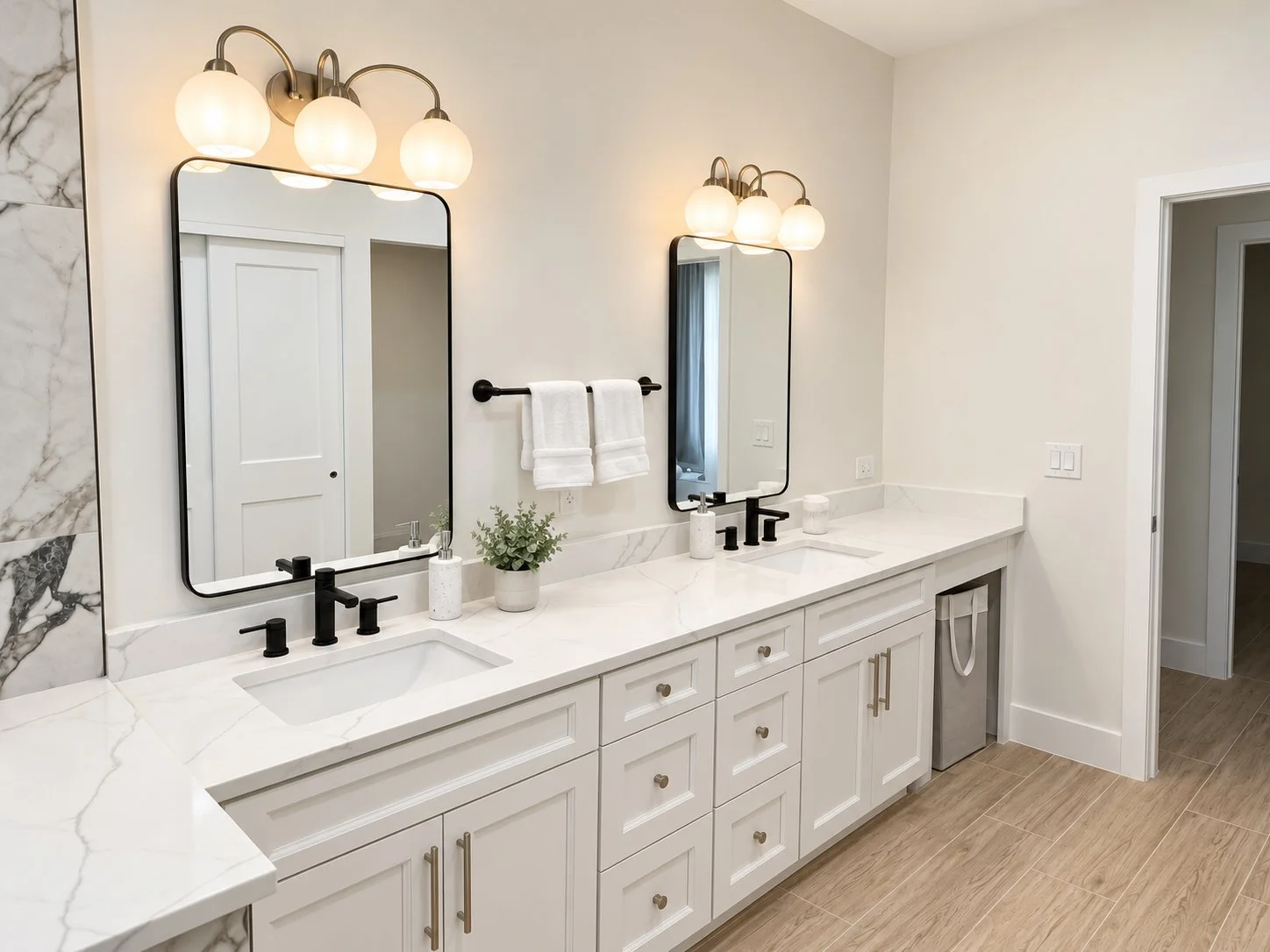 A modern double vanity bathroom with marble countertops, two large rectangular mirrors, black fixtures, a small potted plant, and two wall-mounted light fixtures with three globes each.