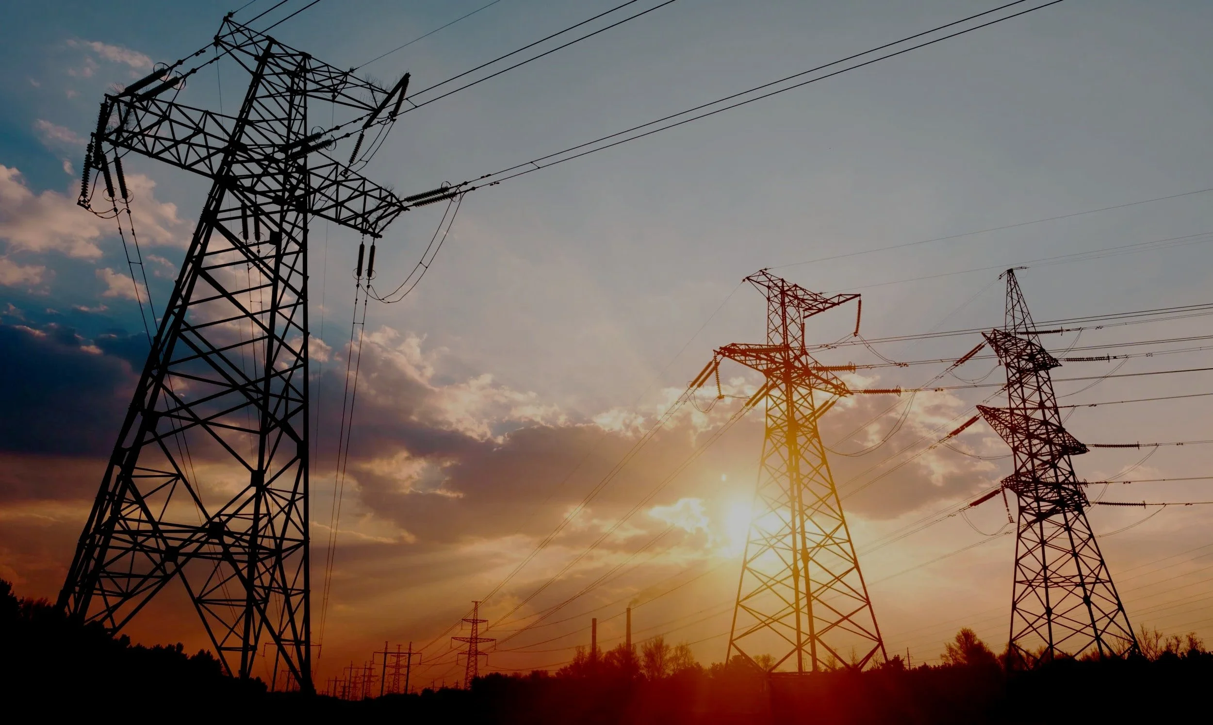 Electrical transmission towers and lines at sunset.