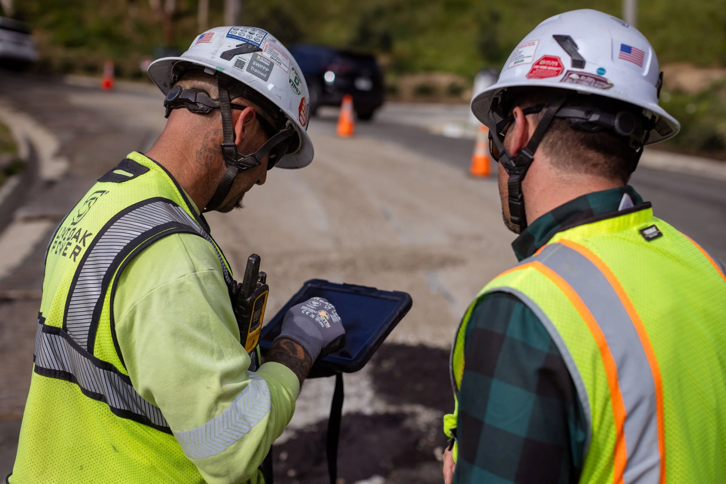 Field leaders reviewing jobsite documentation at an active work zone.