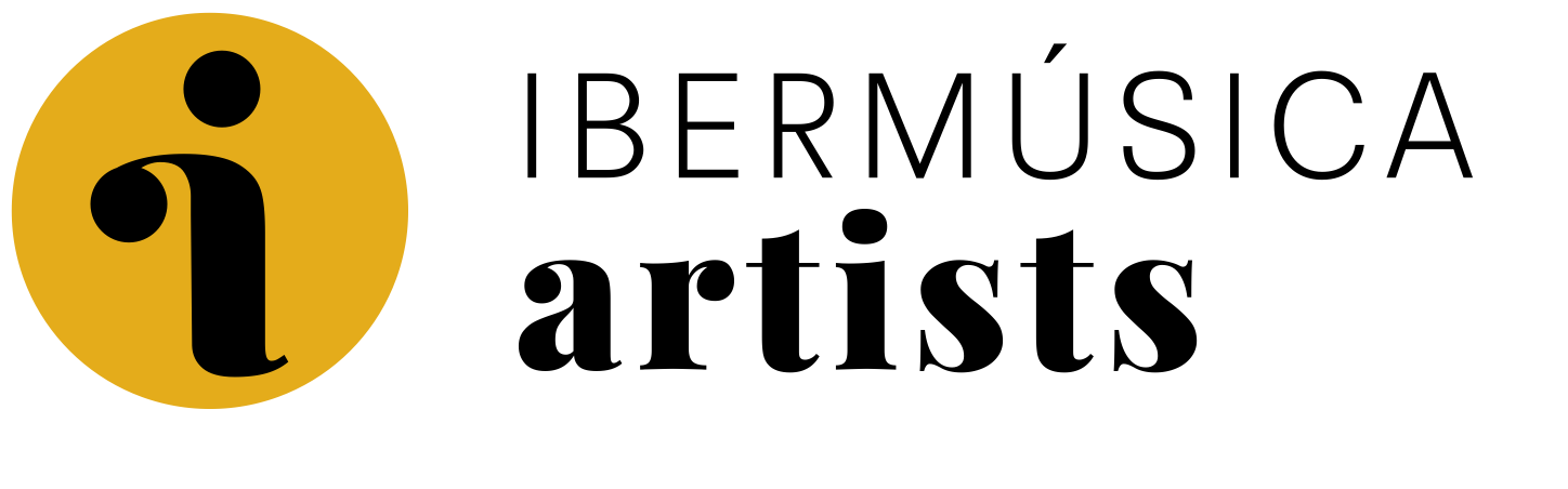Logo for Bermúsika artists, featuring a black lowercase 'i' inside a gold circle, with the words 'Bermúsika artists' next to it in black text.