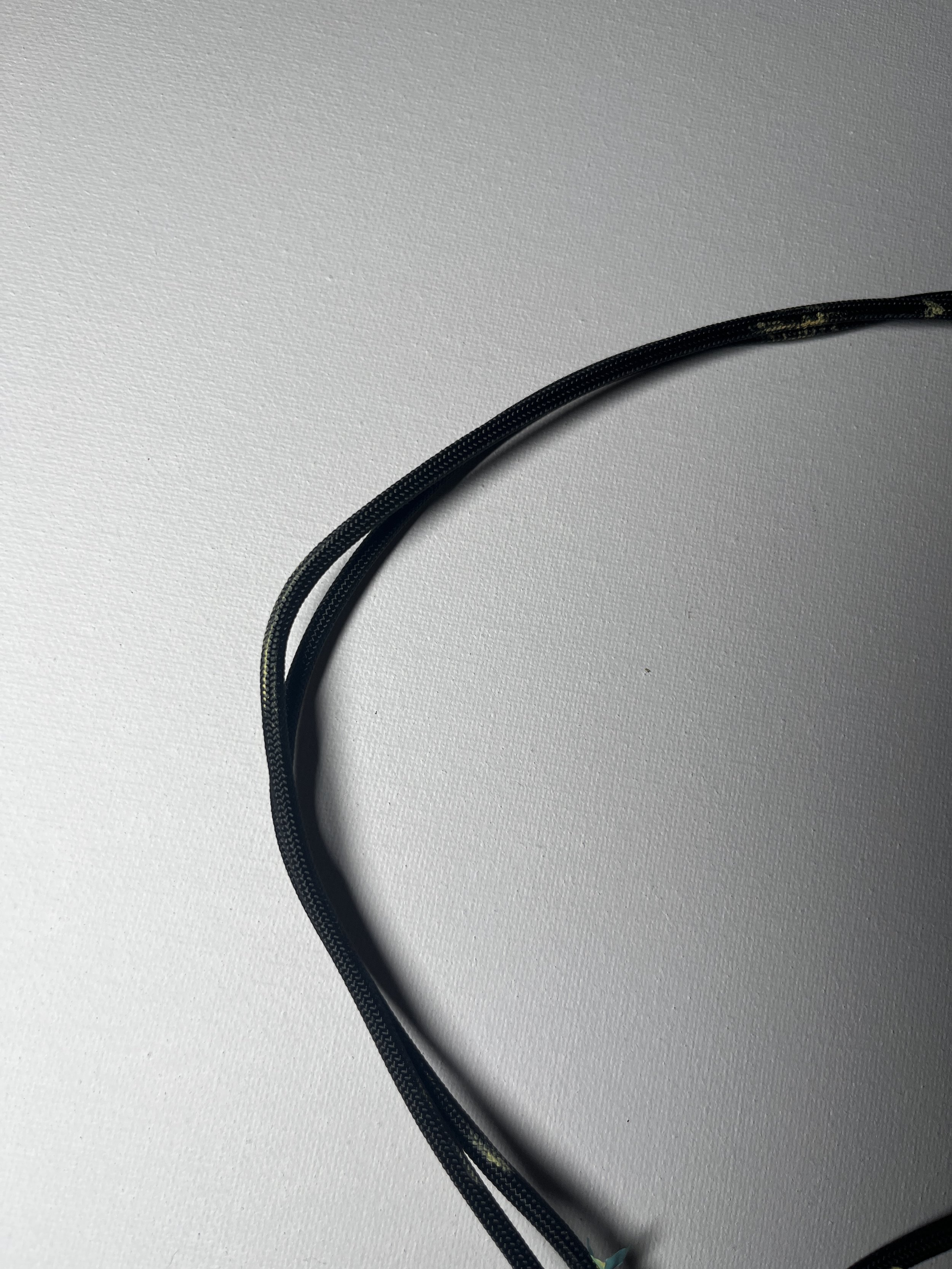 Two black and yellow patterned cables on a white textured surface.