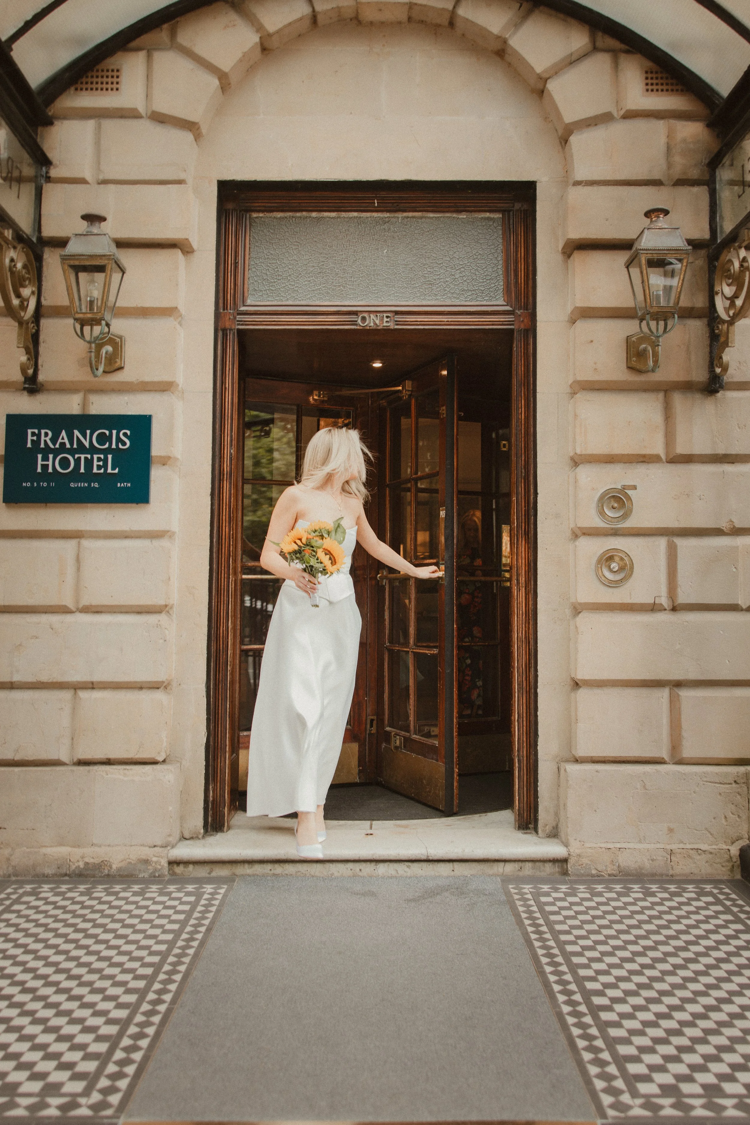 Bride exiting Francis Hotel entrance in Bath, documentary wedding photography - Josh Ward Creative