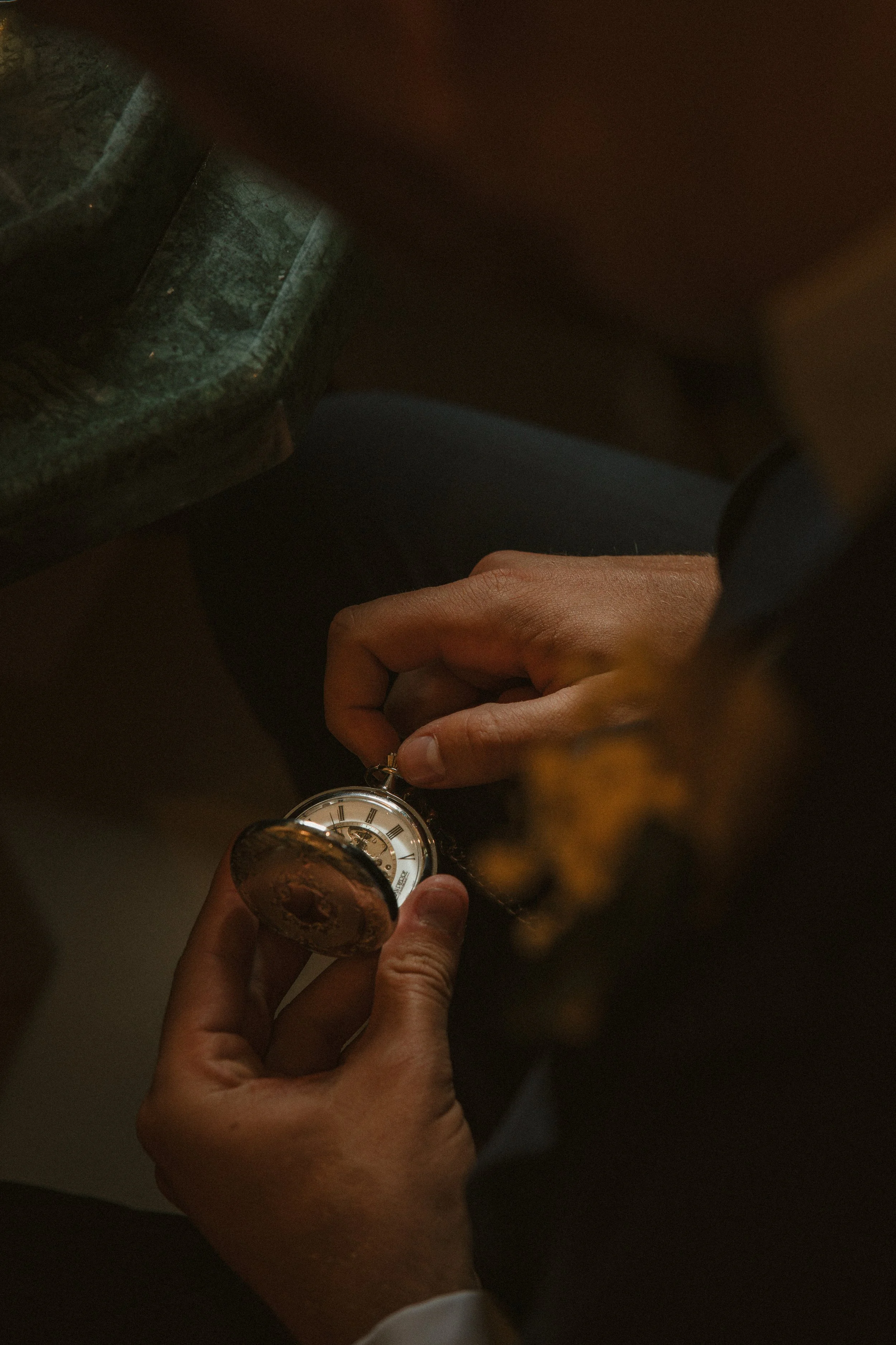 Groom adjusting vintage pocket watch details, wedding morning prep - Josh Ward Creative