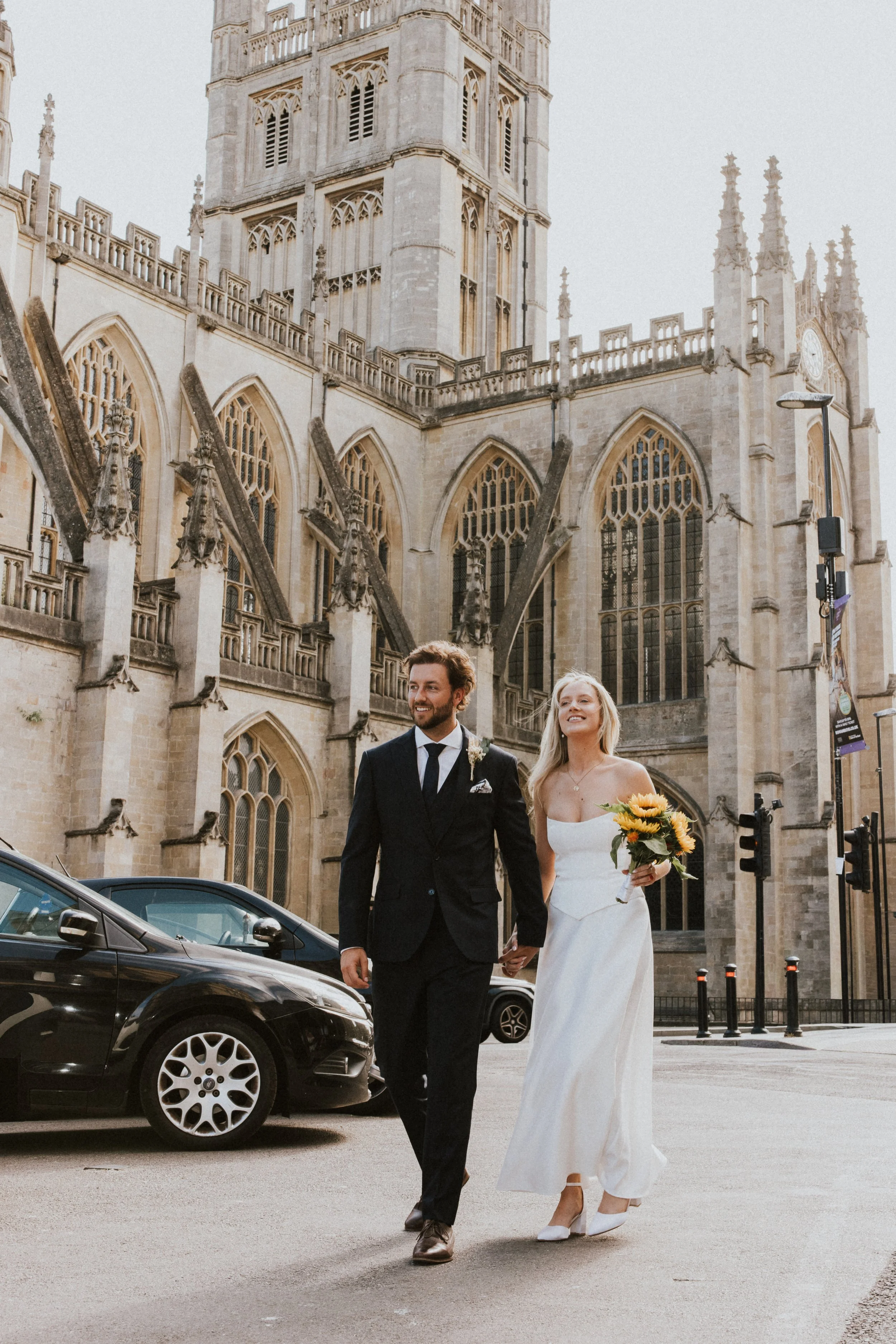 Bride and groom walking past Bath Abbey, Somerset wedding photography - Josh Ward Creative