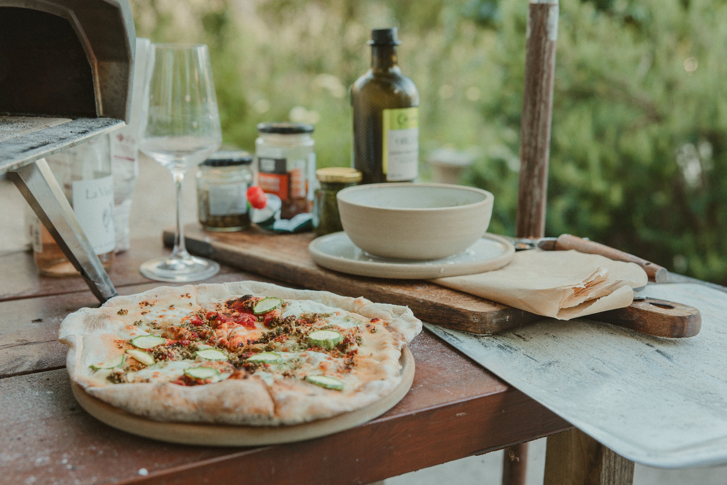 Freshly baked outdoor pizza on wooden board, hospitality food photography - Josh Ward Creative