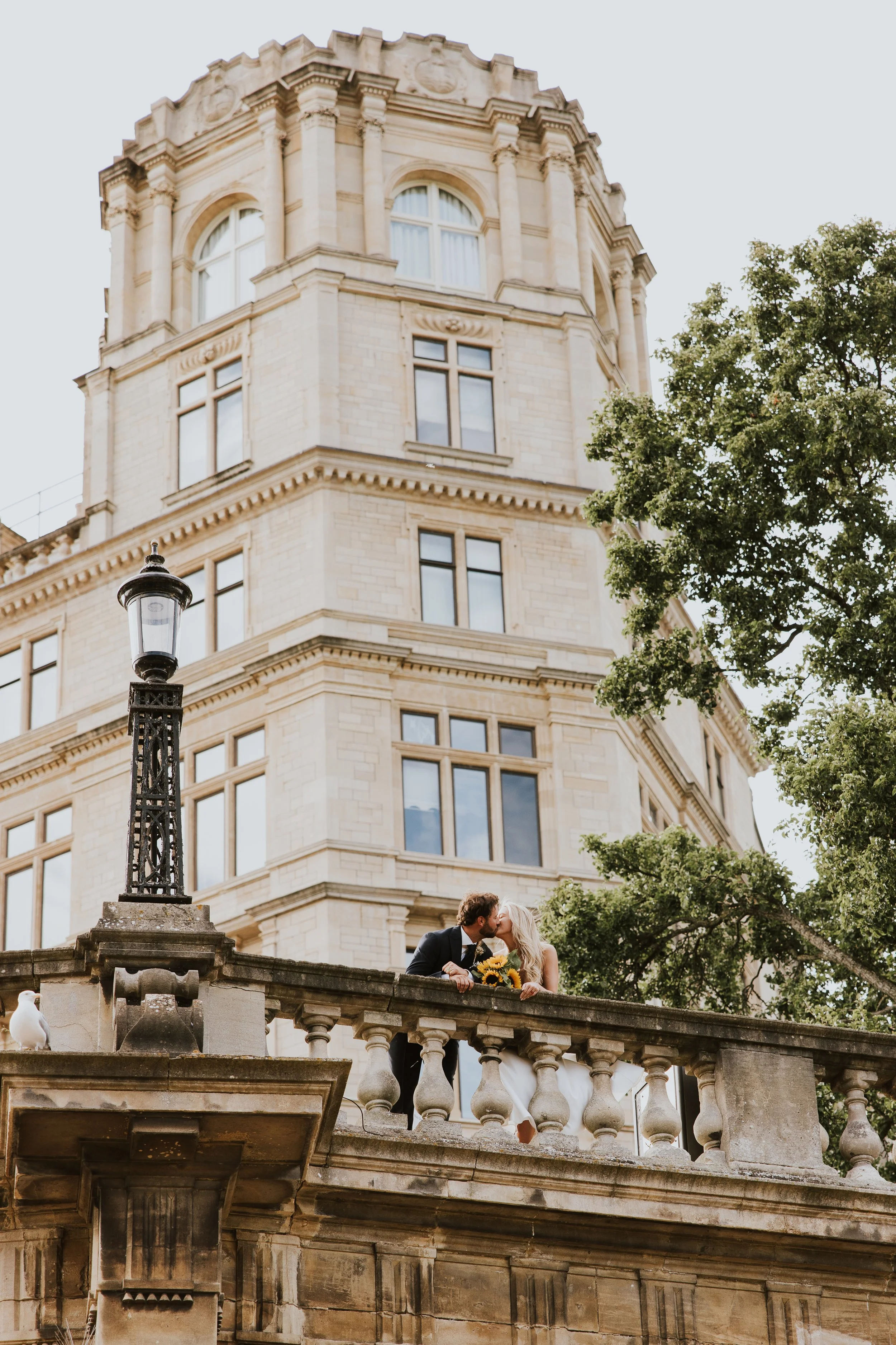Bride and groom on historic stone balcony, South West wedding photography - Josh Ward Creative