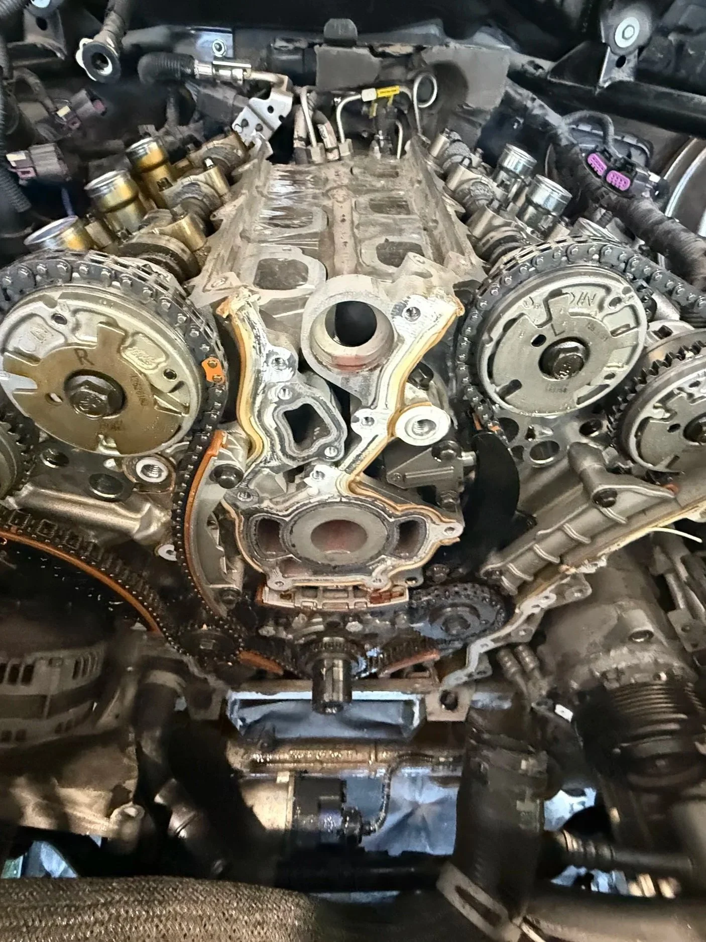 Close-up of a car engine with the timing chain and camshafts visible, showing internal mechanical components.