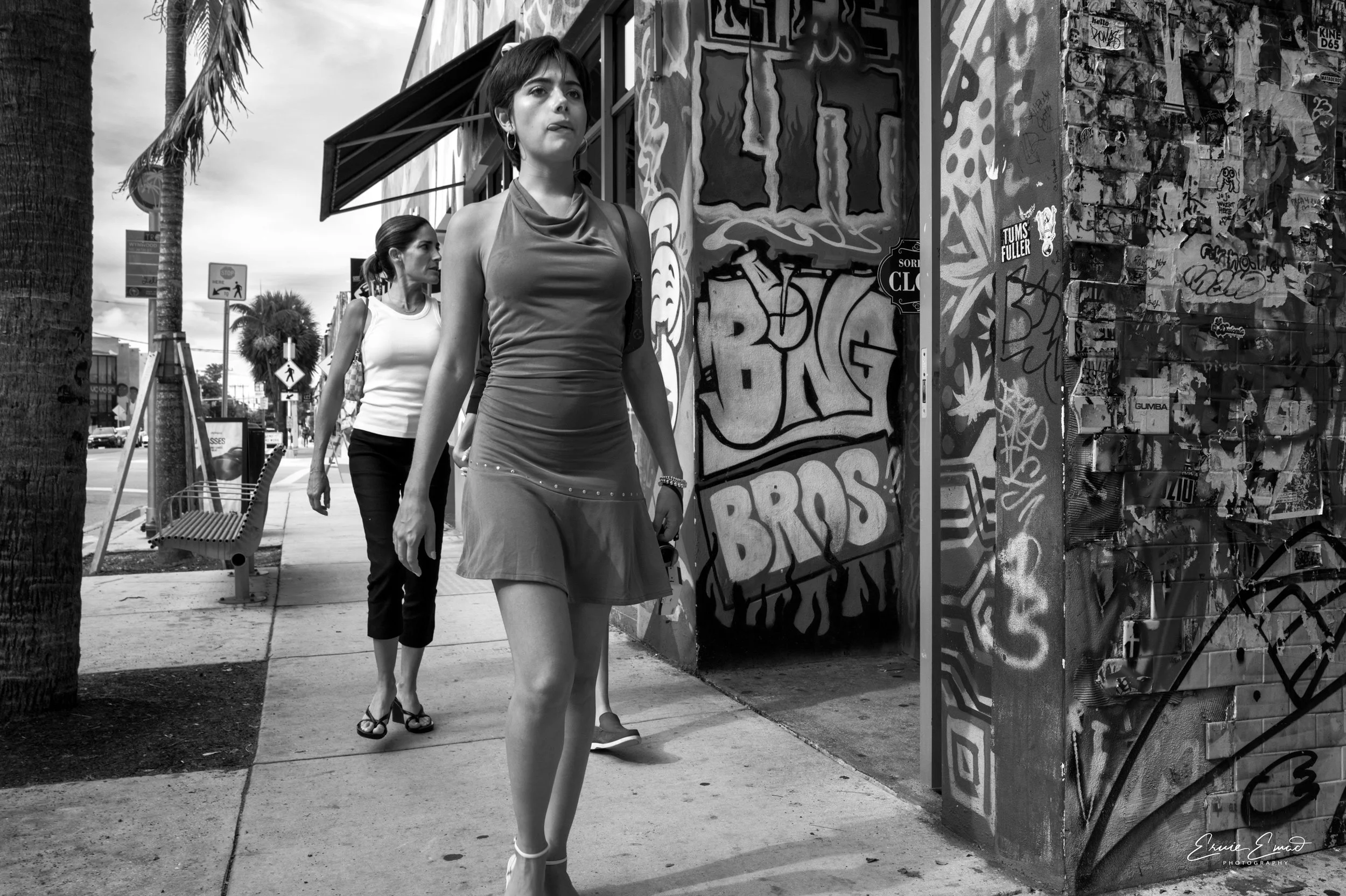 A lady with her tongue sticking out as she passes a Bang Bros Mural in Wynwood Miami