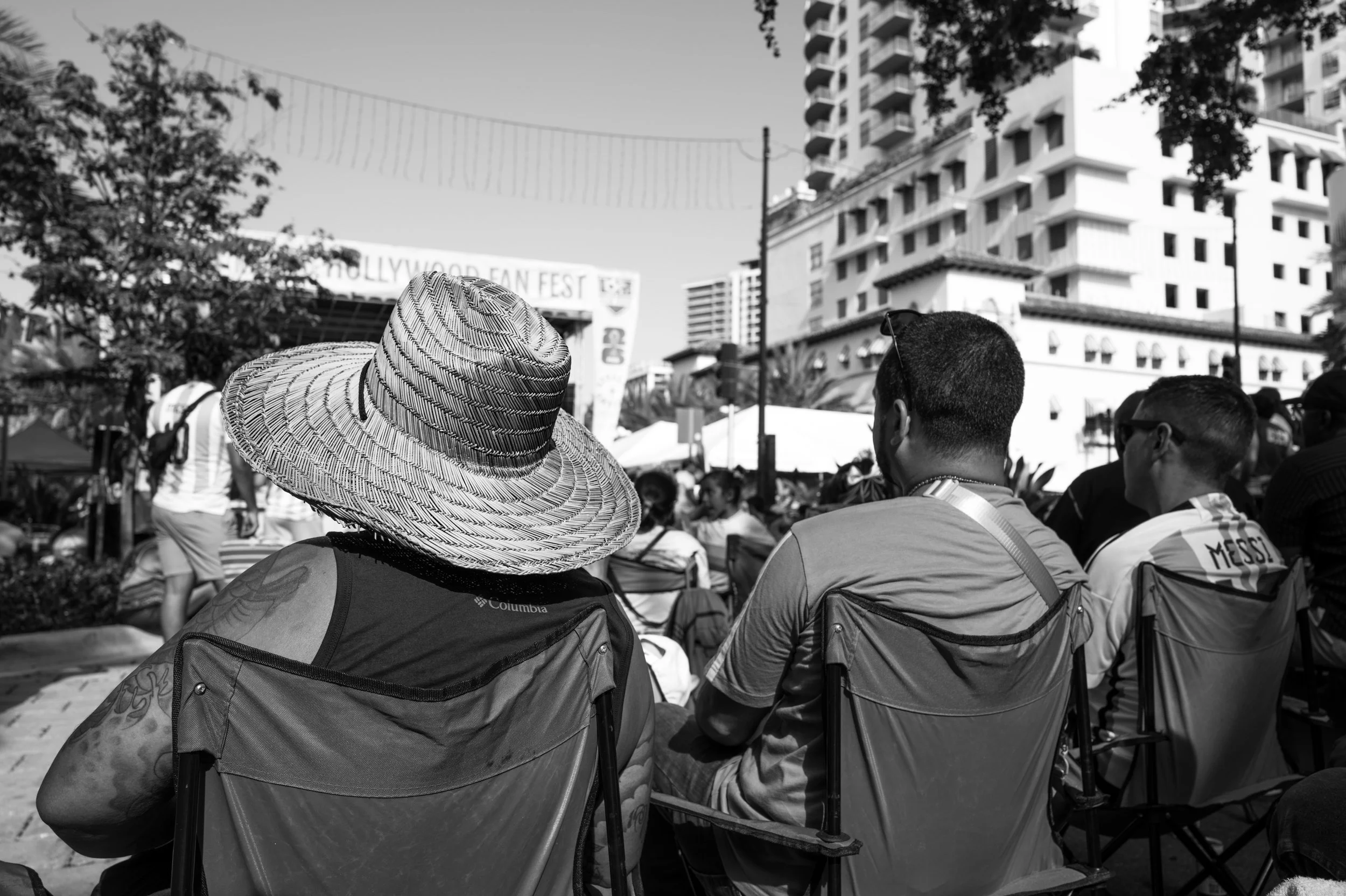 Straw hat watching an outdoor soccer match with Argentina Playing on the Big Screen