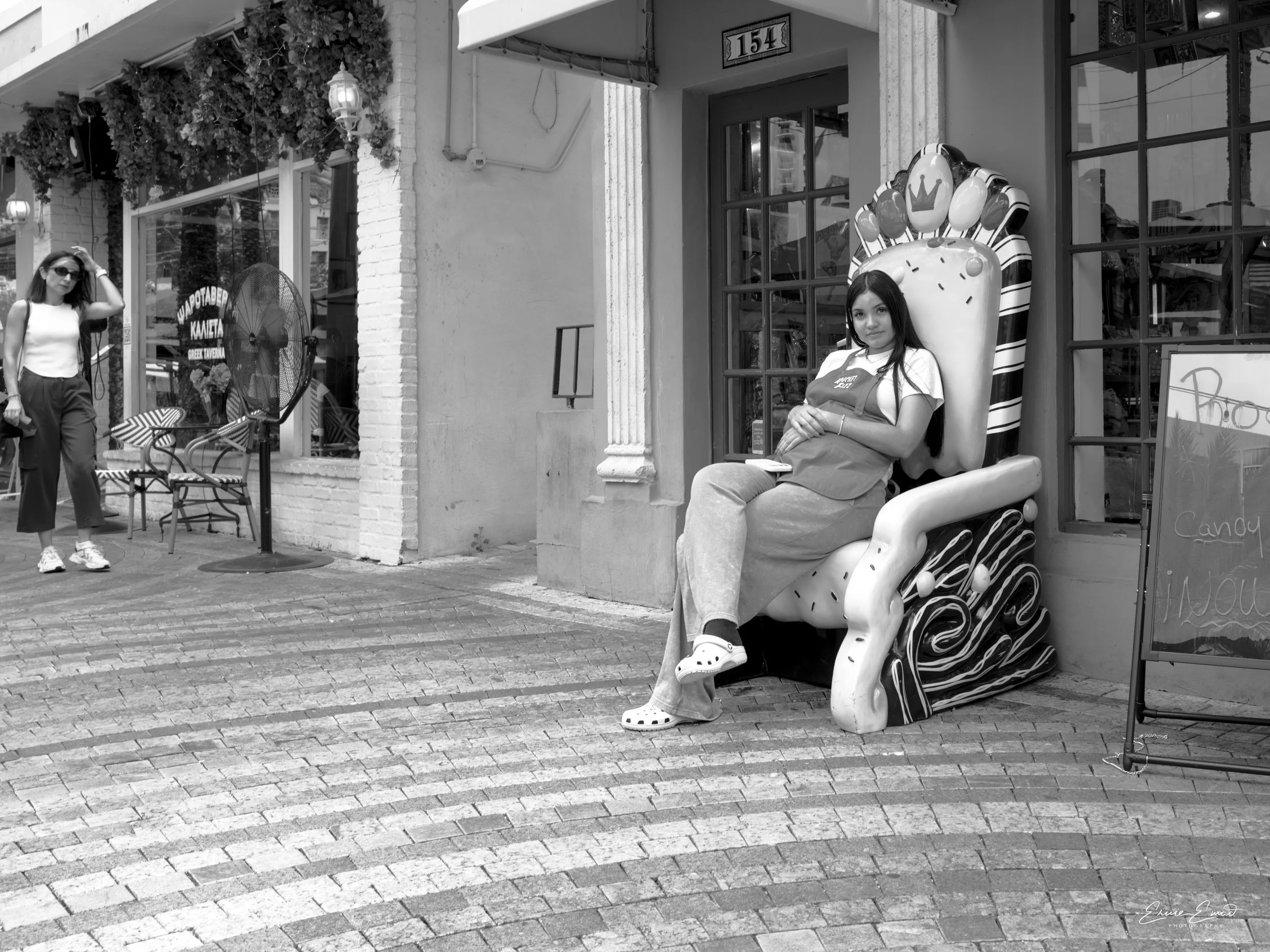 In Coral Gables, Giralda Plaza a pregnant employee is taking a break sitting on a Queens style chair
