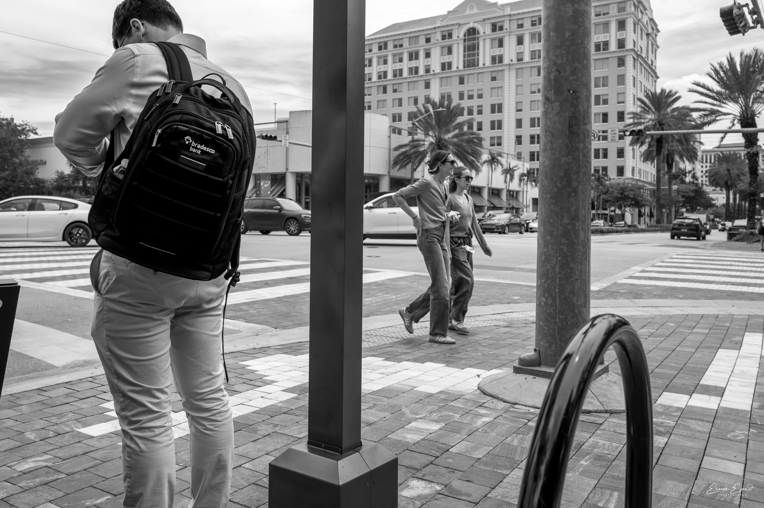 Between traffic poles pedestrians going on their merry way, unbeknownst to them they are in the same frame