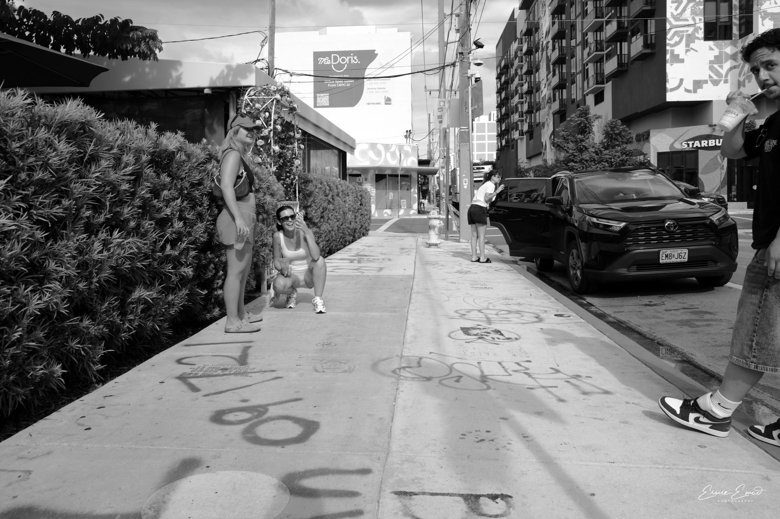 A couple of young ladies taking a picture of a guy that is looking at my camera instead-wynwood miami