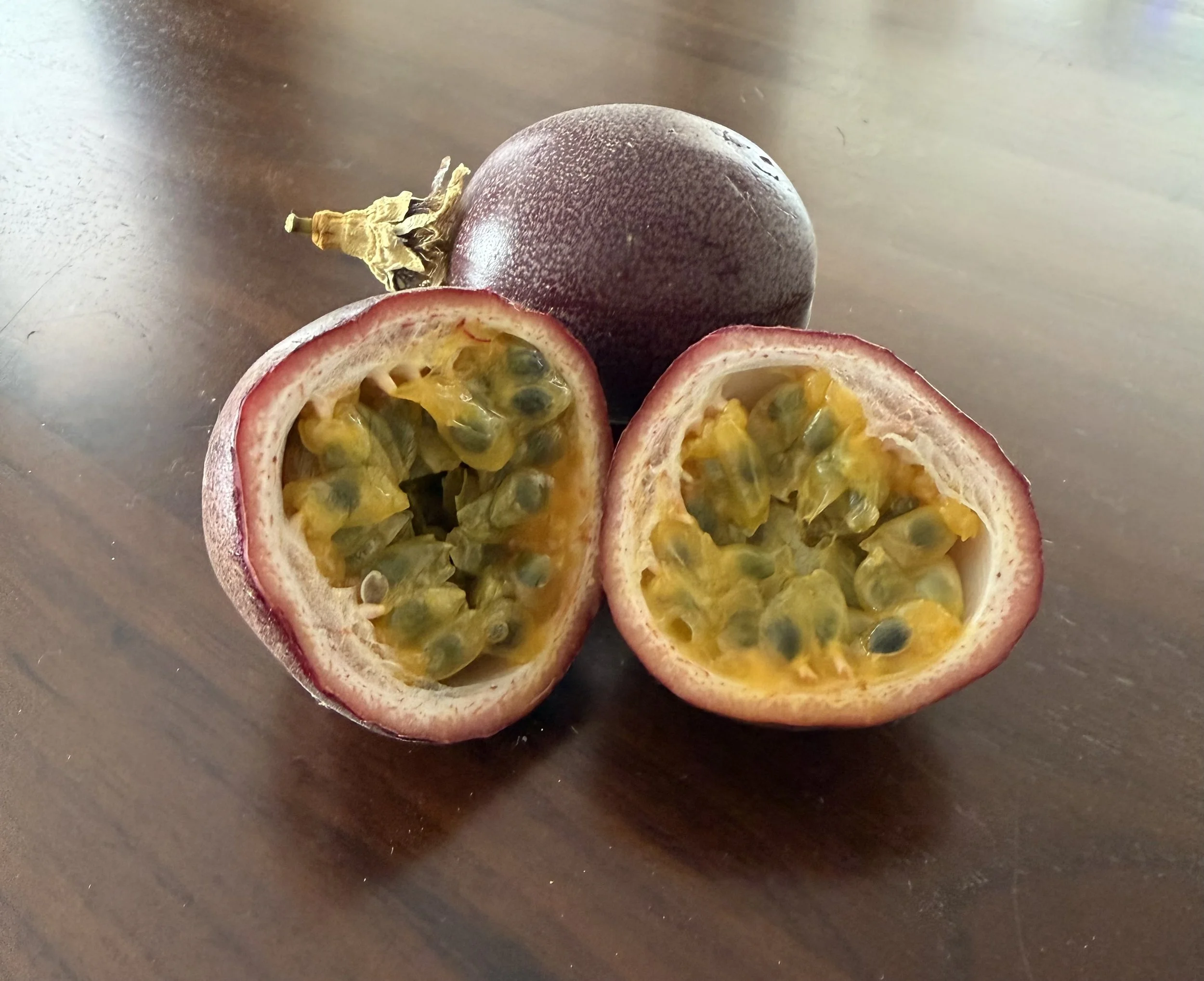 Ripe passionfruit cut open to show the pulp and seeds