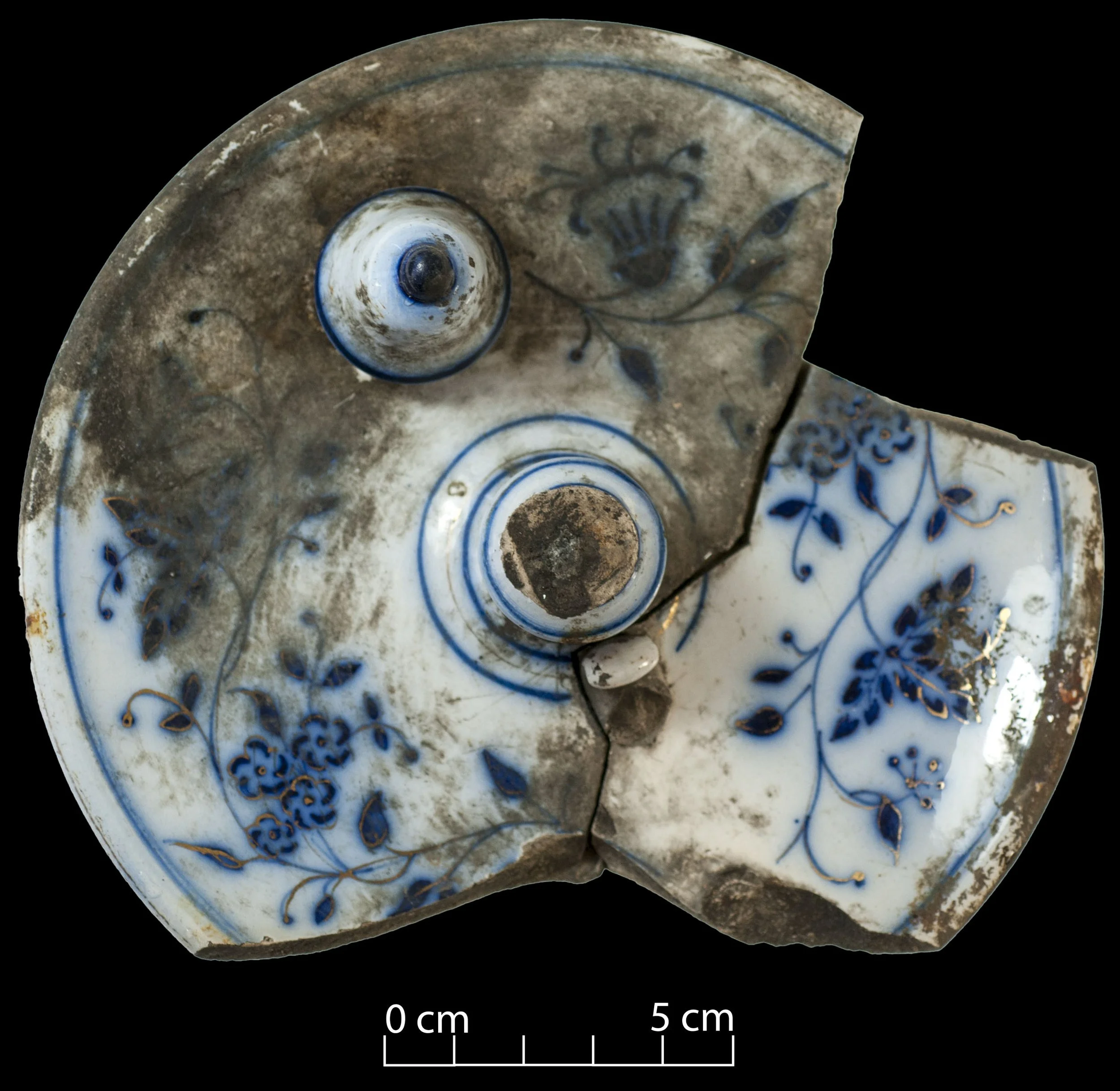 White earthenware candlestick, with blue floral pattern. Dirty, incomplete, broken.