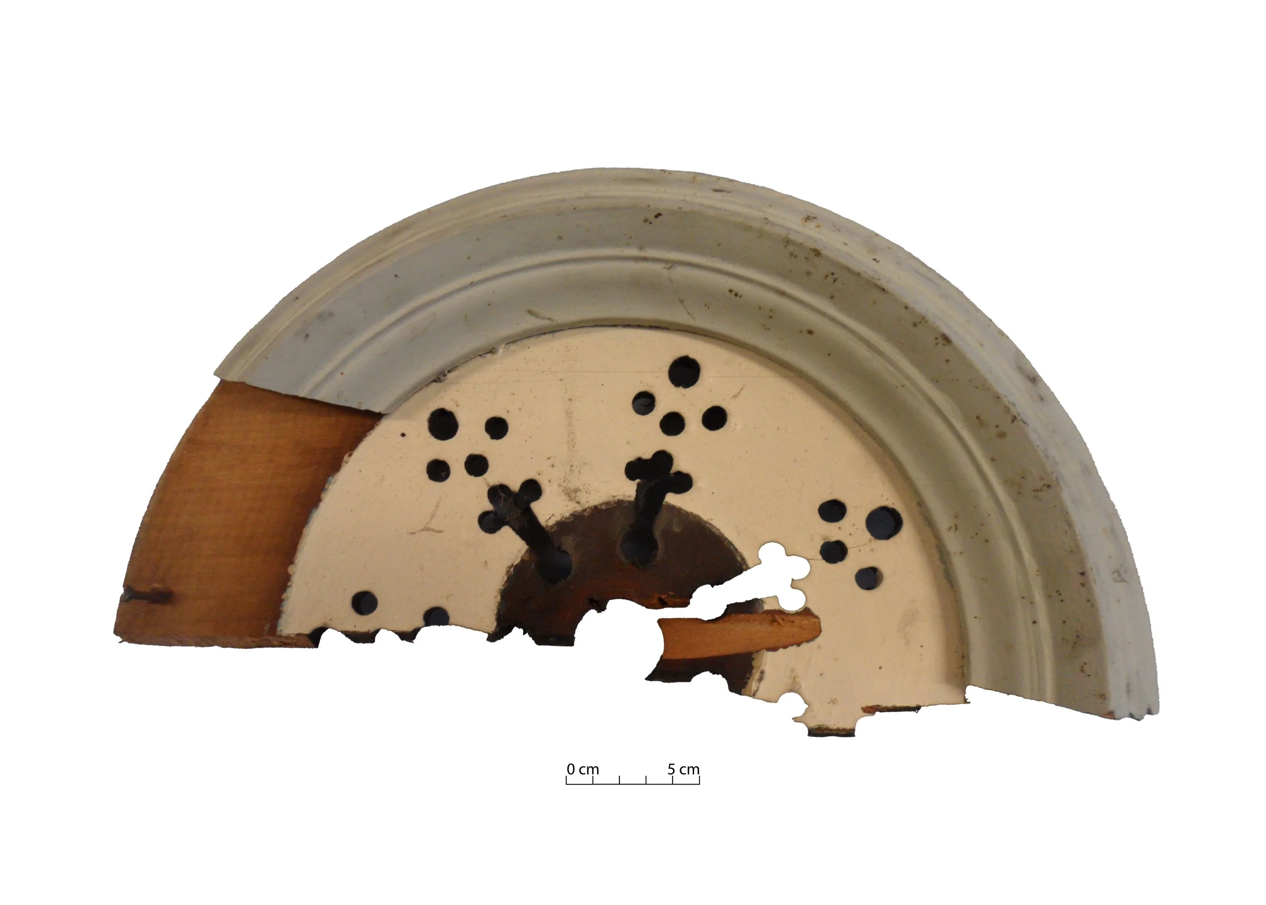 Half of a wooden ceiling rose, with perforations.