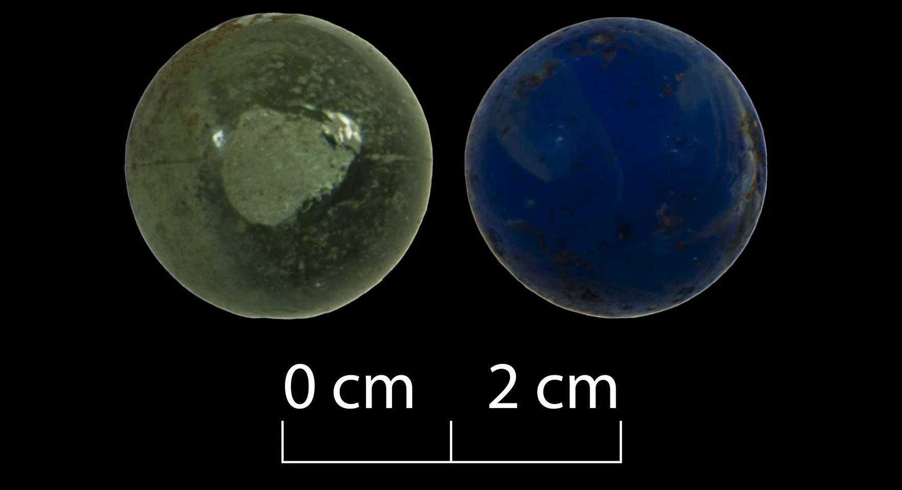 Two marbles, one light green, the other cobalt blue.