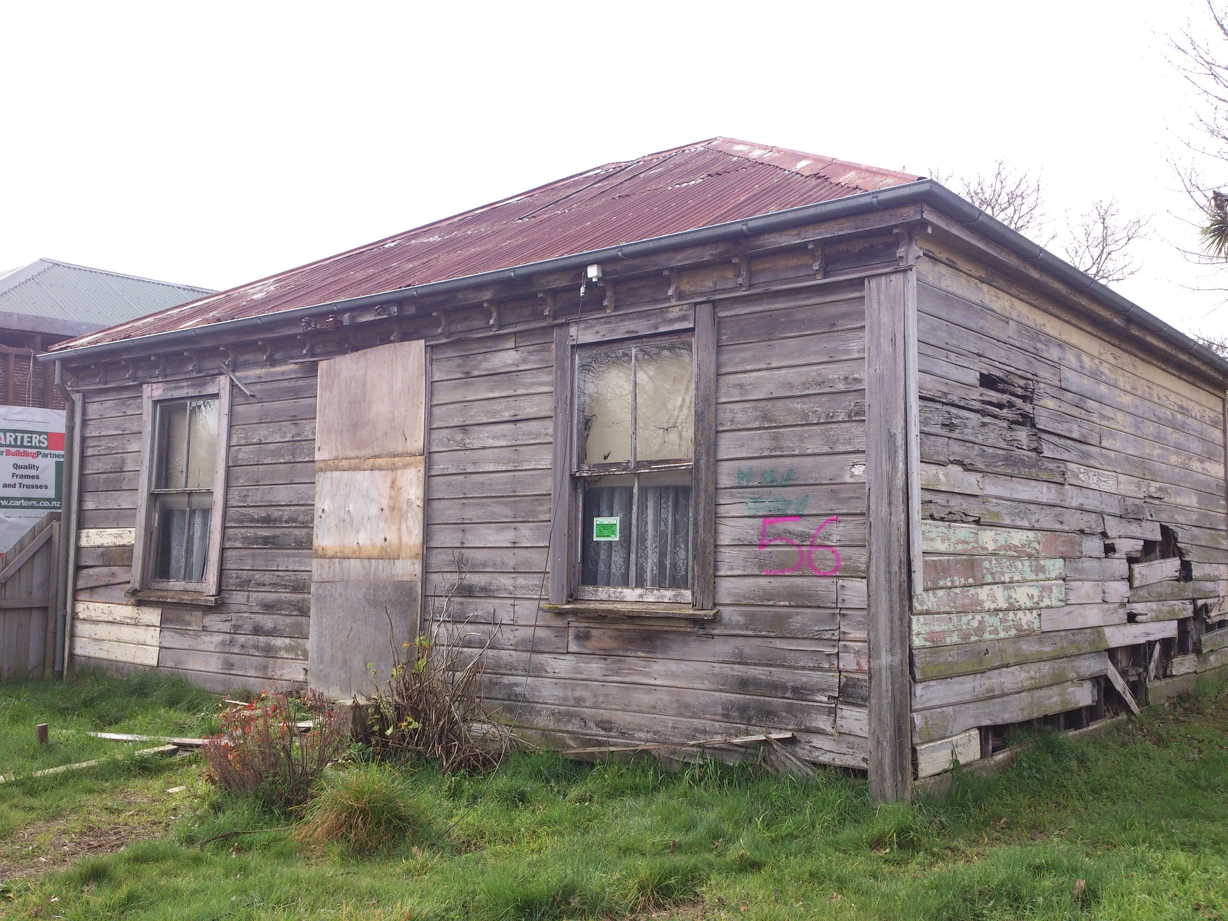 A single storey weatherboard house, corrugated iron roof, no veranda. Central front door, single sash window each side of the door, eaves brackets, rusticated weatherboards. Poor state of repair.