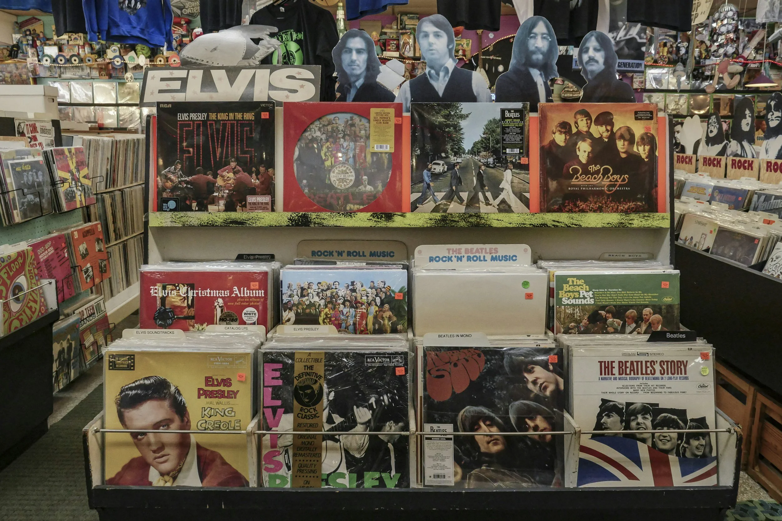 Display of vinyl records of The Beatles, Elvis Presley, The Beach Boys, and other classic rock artists in a record store.