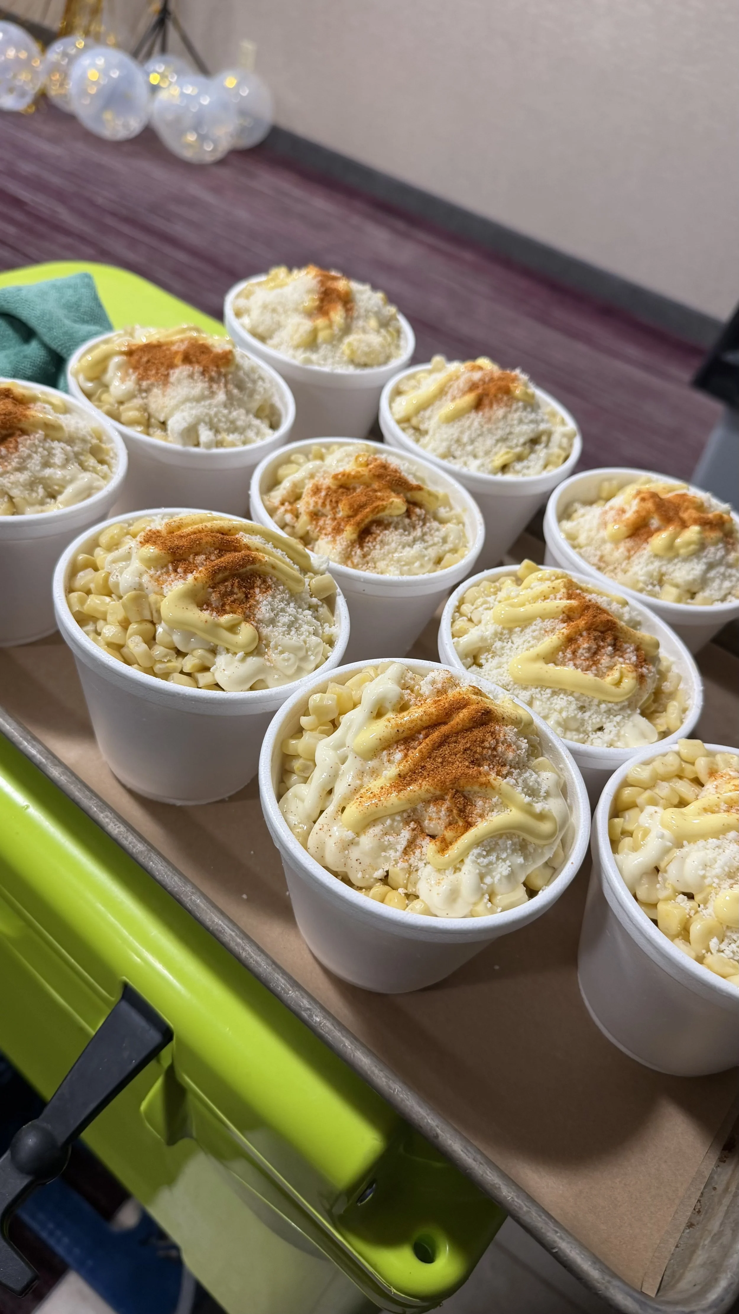 Multiple cups of macaroni and cheese topped with grated cheese and paprika.