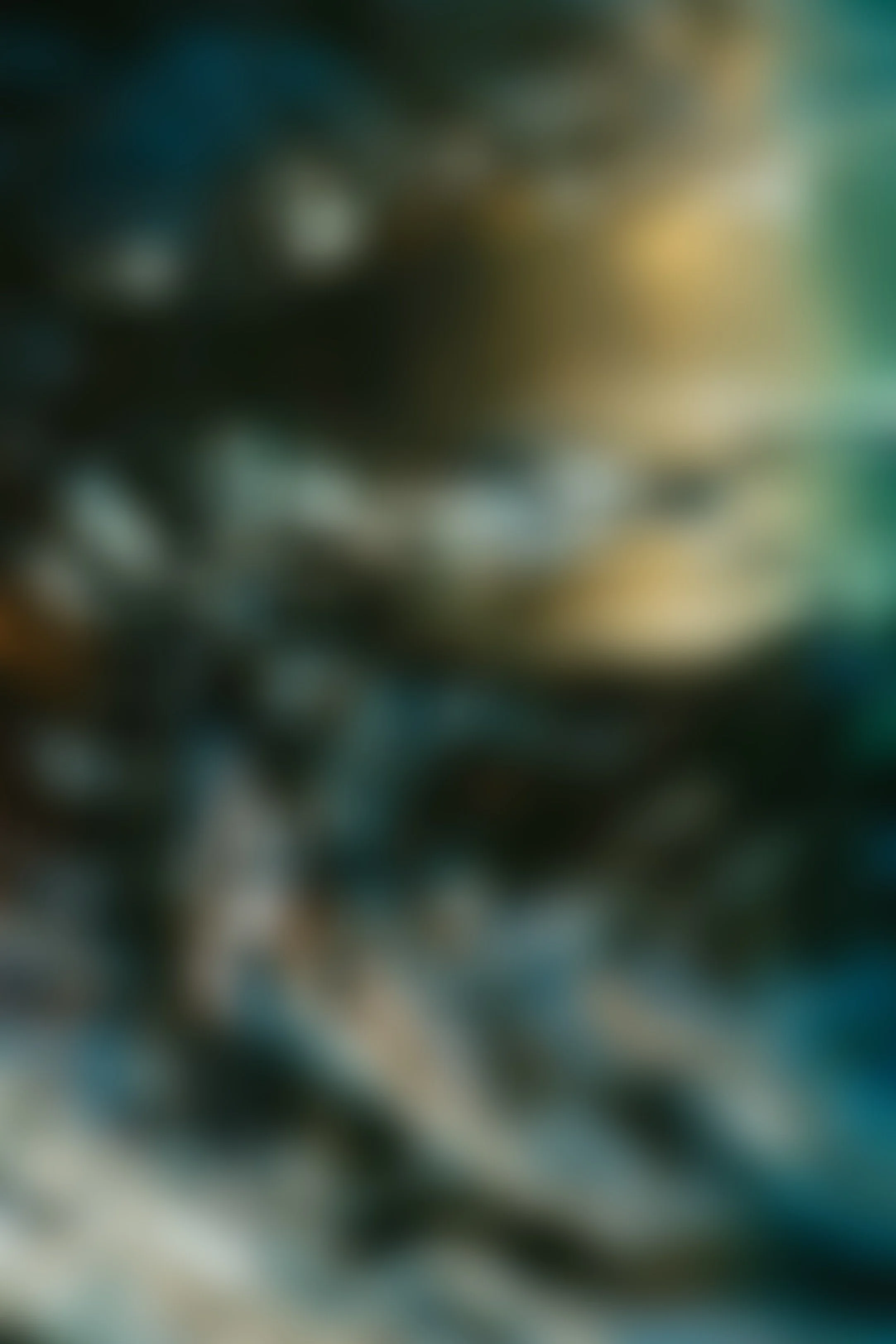 Blurred abstract image with shades of blue, green, black, and yellow.