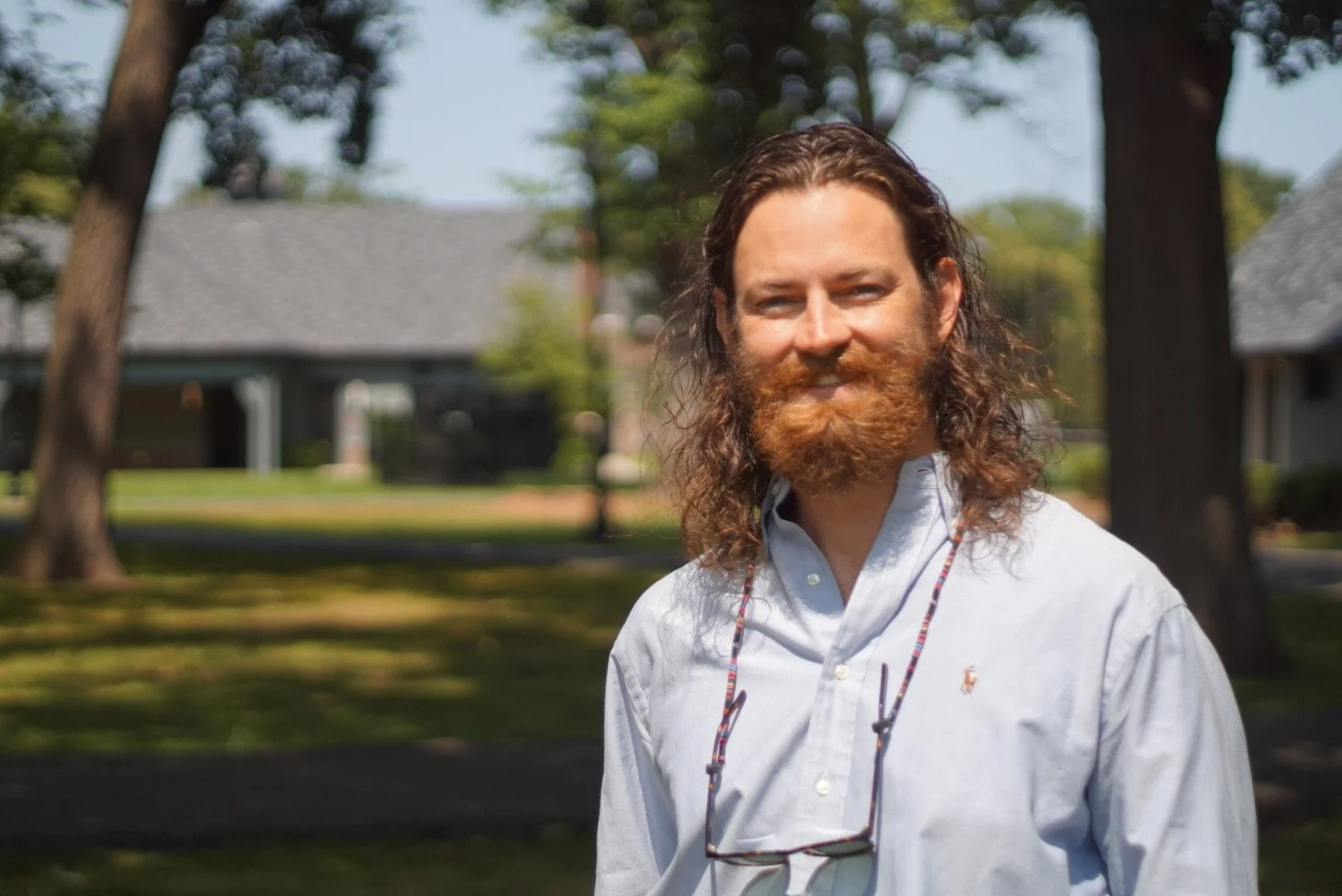 Kyle Porro smiling on a tree-lined residential street