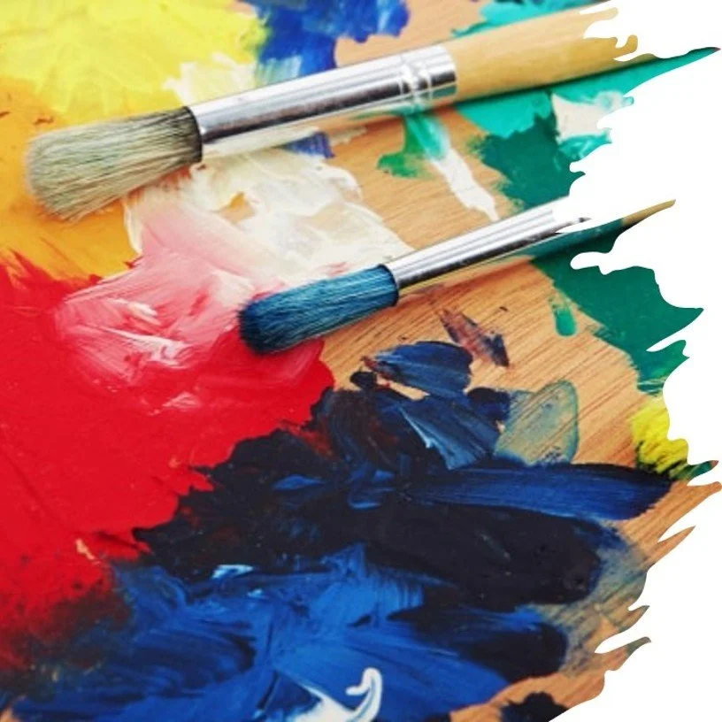 Two paintbrushes on a colorful palette with mixed paints, including red, blue, yellow, green, and white.
