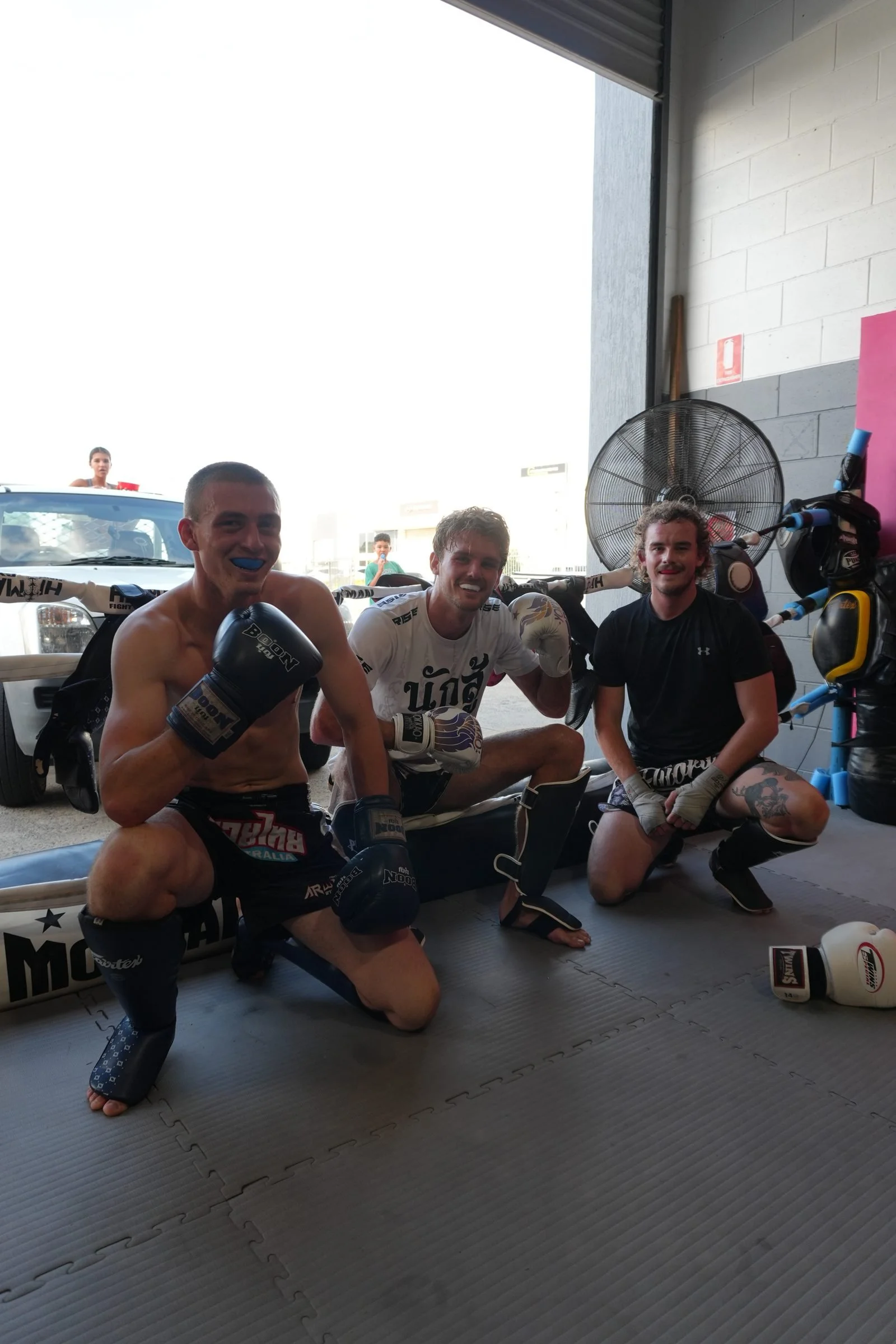 Members smiling on the mats after a Muay Thai session at DM Muay Thai & Fitness, Tweed Heads