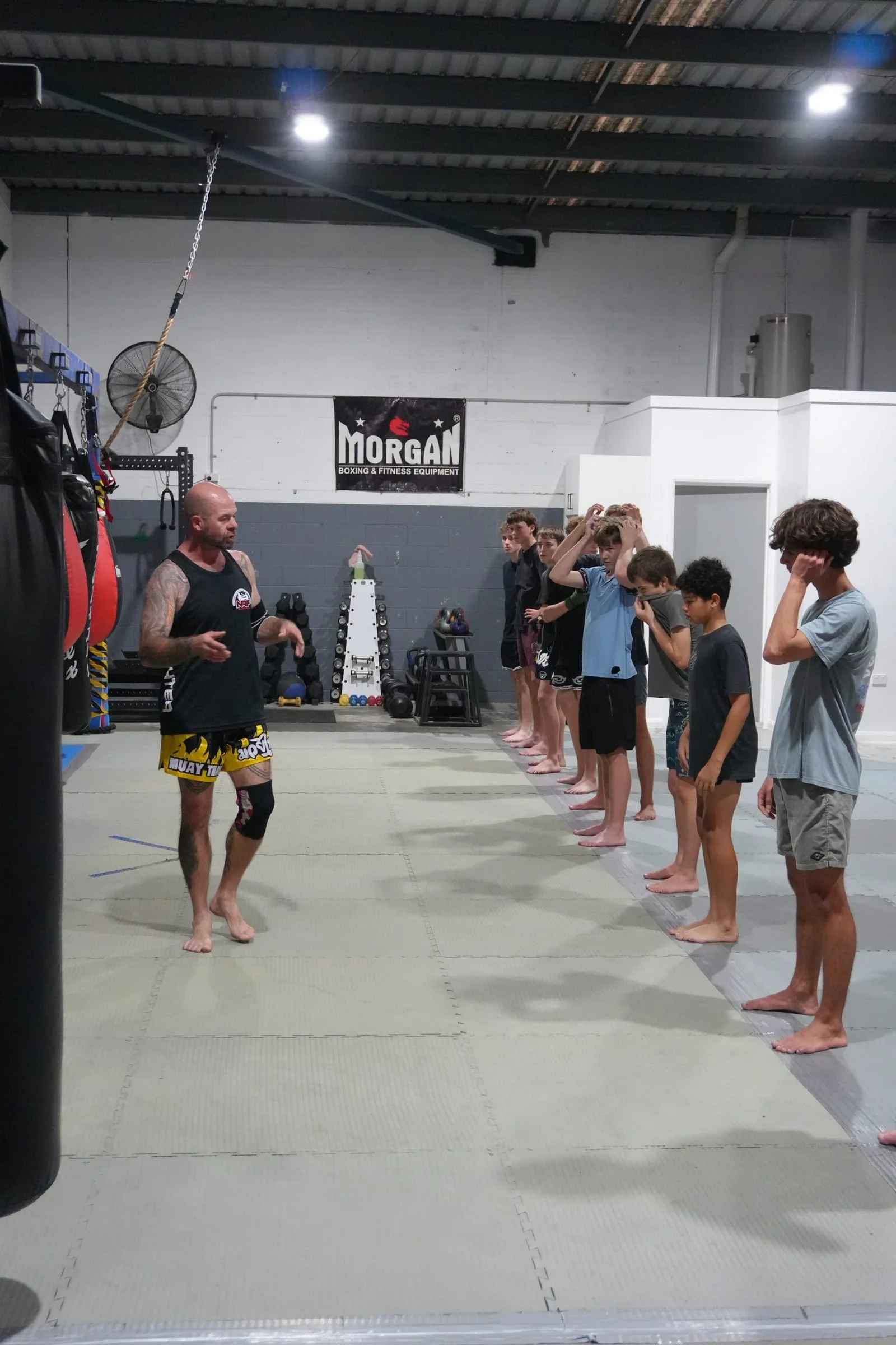Teens lined up in guard during a Muay Thai class with their coach at DM Muay Thai & Fitness, Tweed Heads